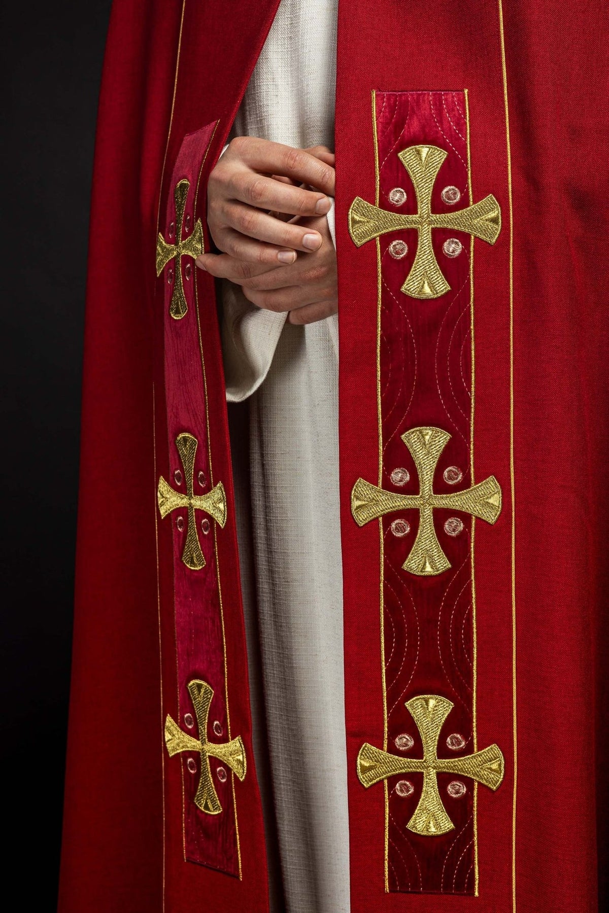 Red velvet cope close-up showing gold clasp and trim