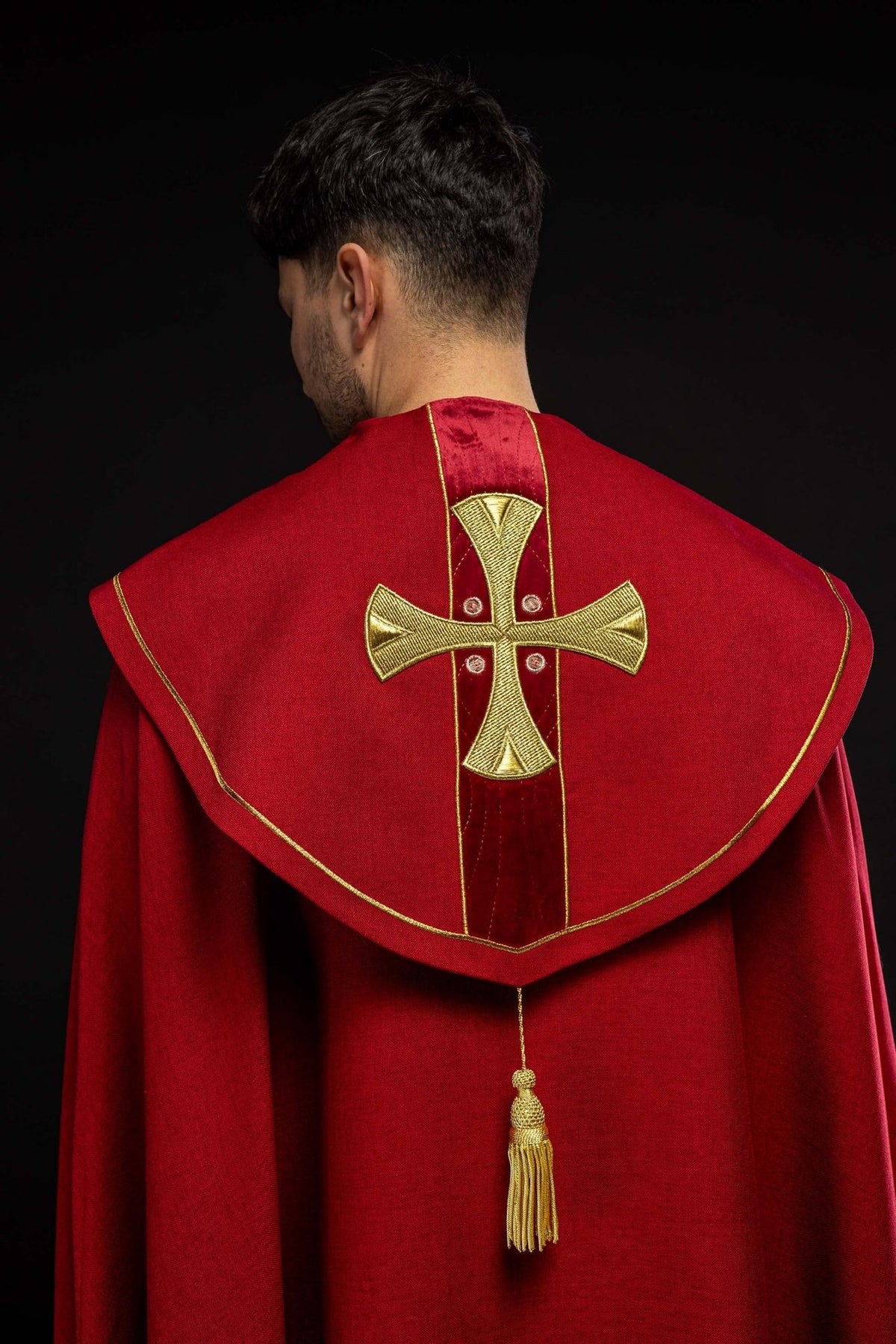 Red cope sleeve detail with gold cross embroidery and trim