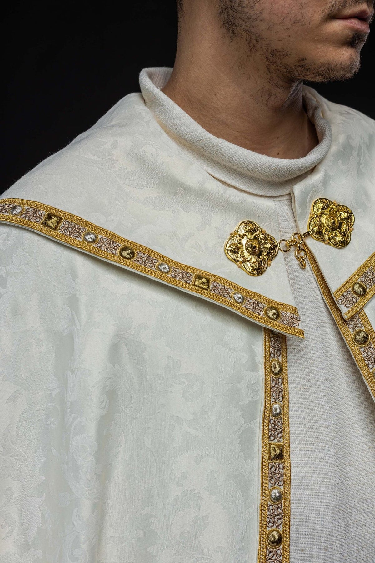 Ecru cope front close-up showing gold clasp, collar and embroidered trim
