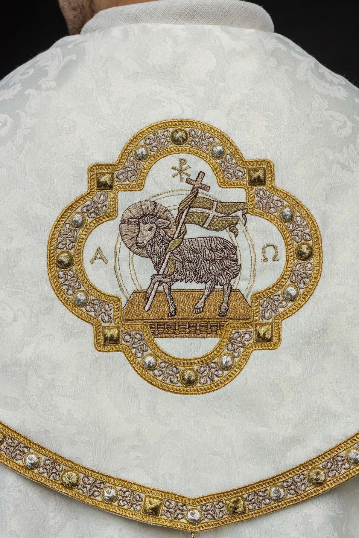 Ecru cope close-up of Paschal Lamb embroidery with Alpha and Omega symbols