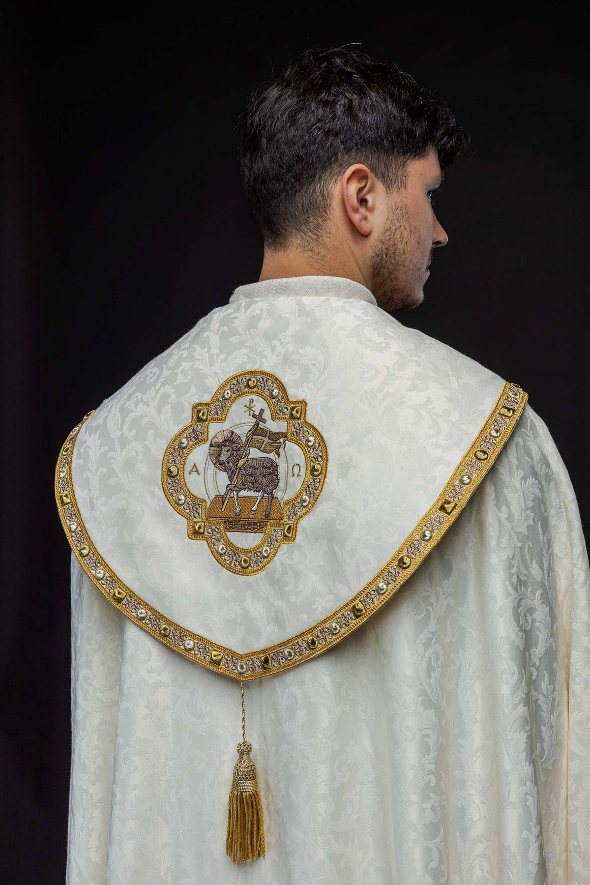 Ecru cope side close-up showing jacquard fabric and gold embroidered edging