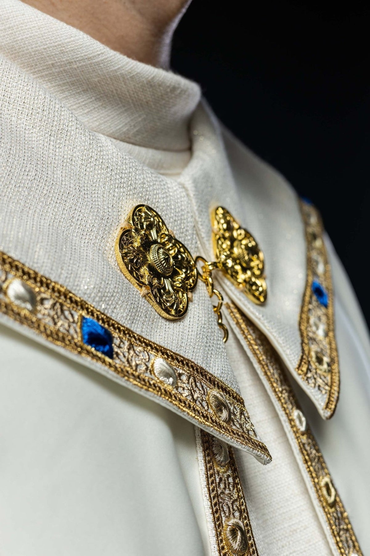 Embroidered cope close-up showing gold clasp and ornate trim