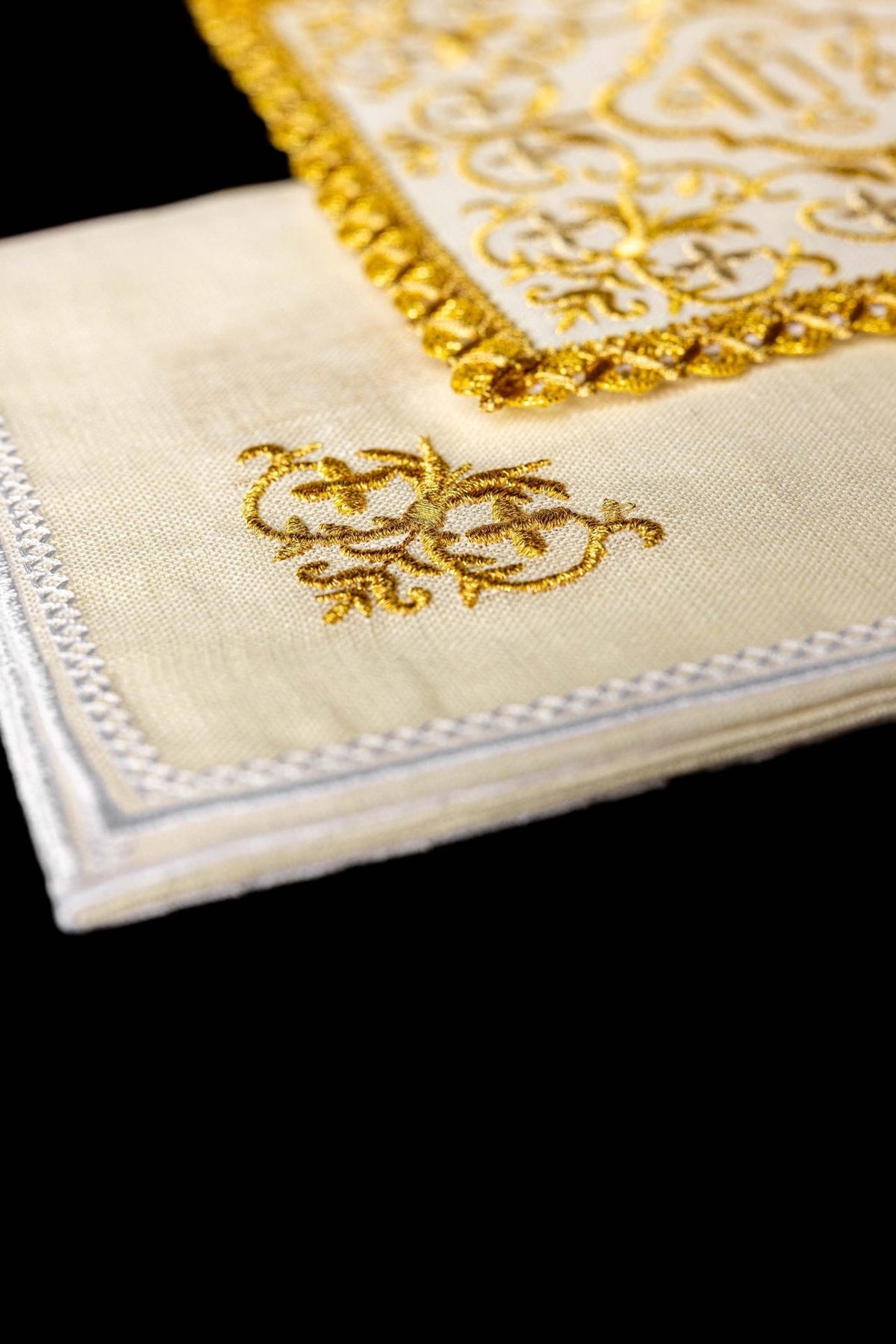 Altar linen set close-up showing gold embroidered cross and white stitched border