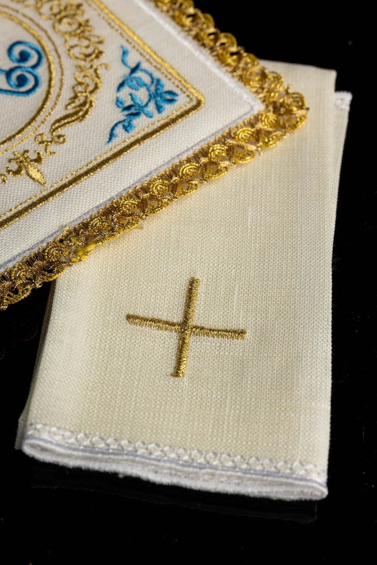 Altar linen set detail showing white linen fabric with gold cross embroidery