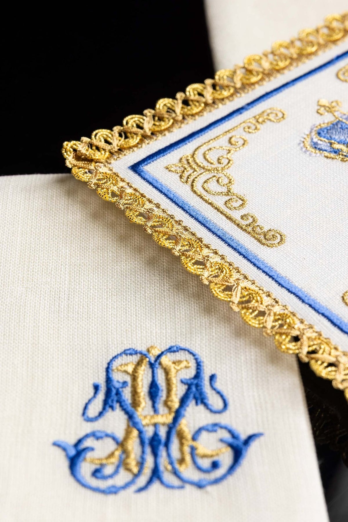Altar linen detail showing blue and gold Marian motif embroidery and ornate gold trim