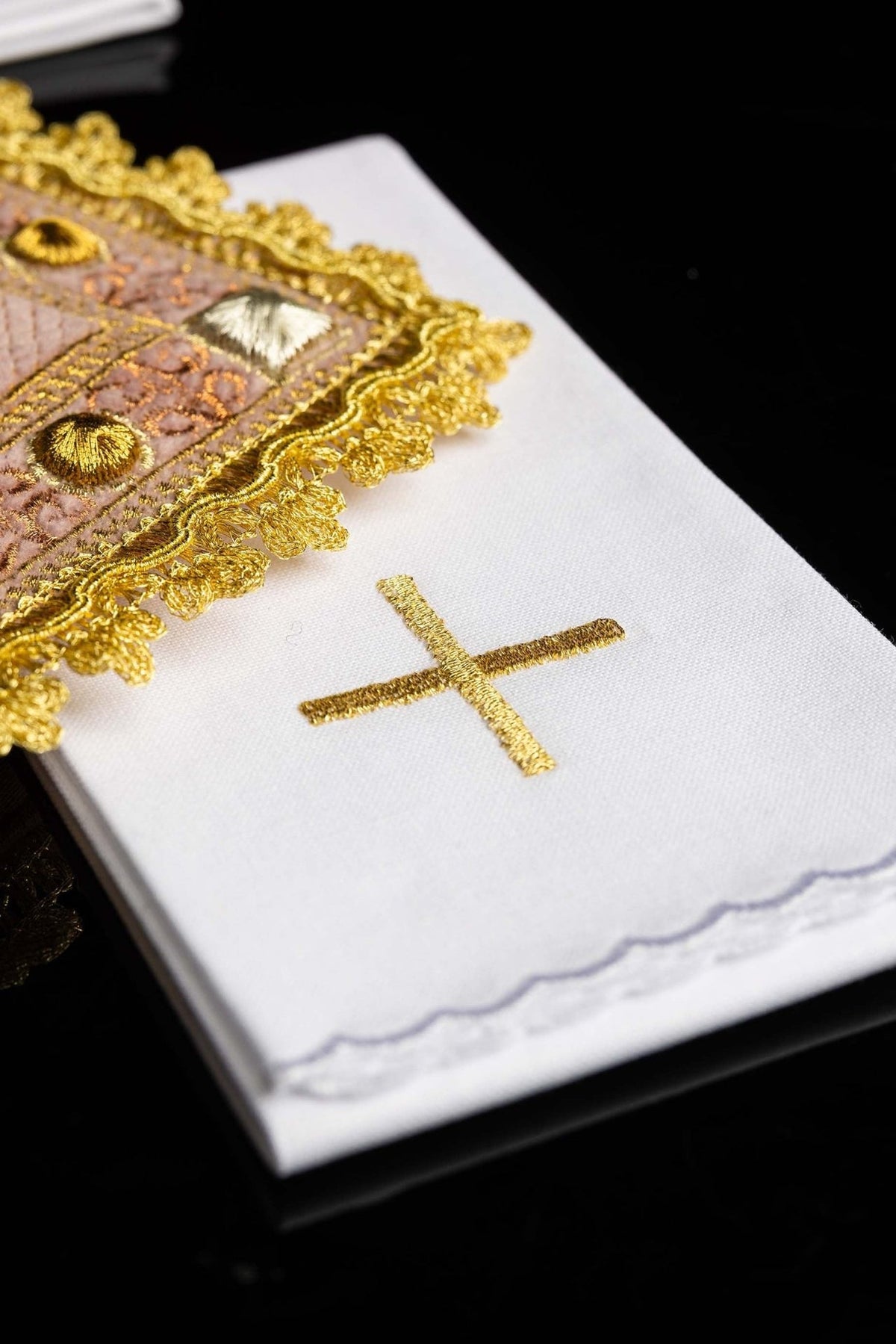 White altar linen set close-up showing gold embroidered cross and rose velvet corporal