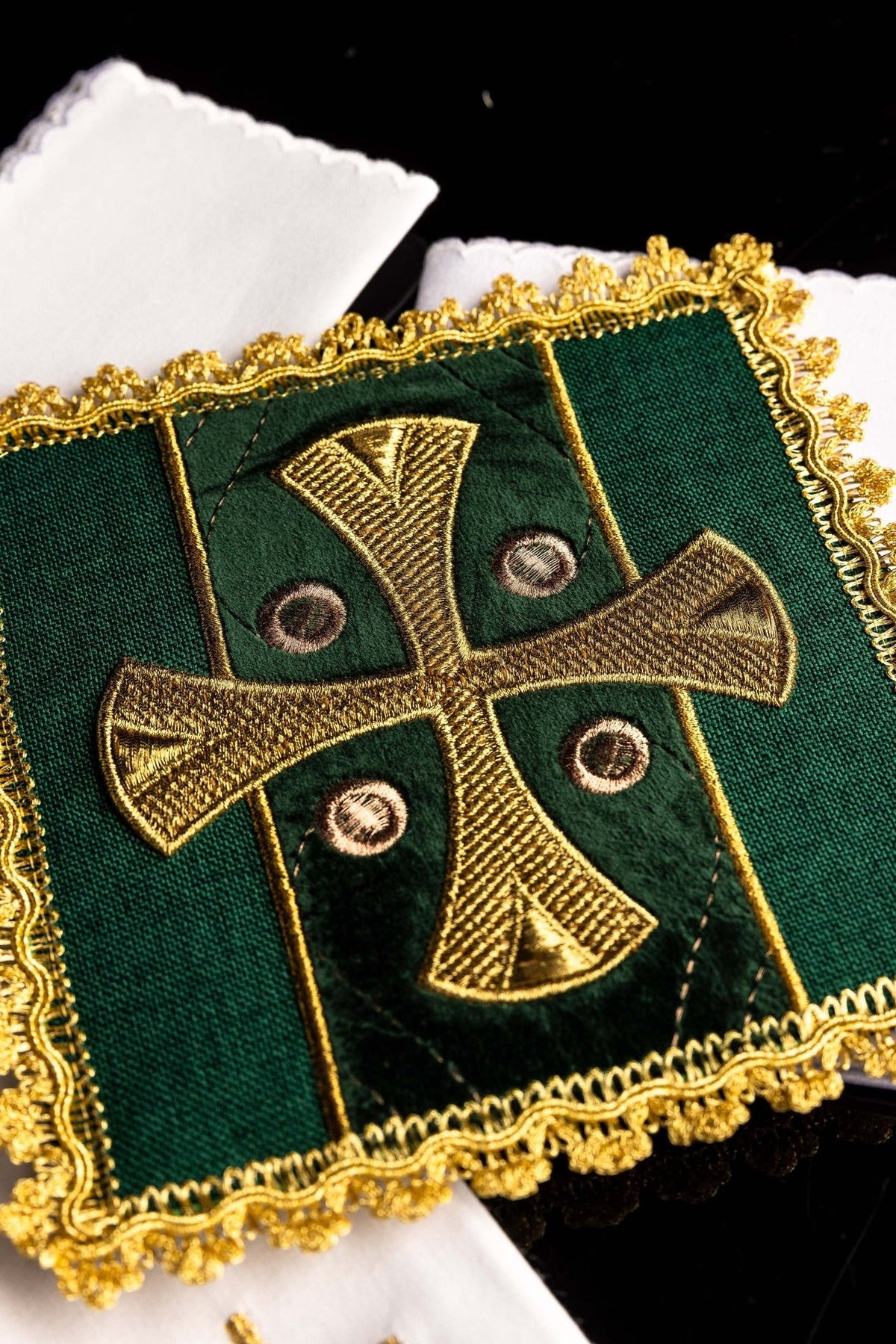 Green altar linen set pall close-up with embroidered gold cross and ornate gold trim
