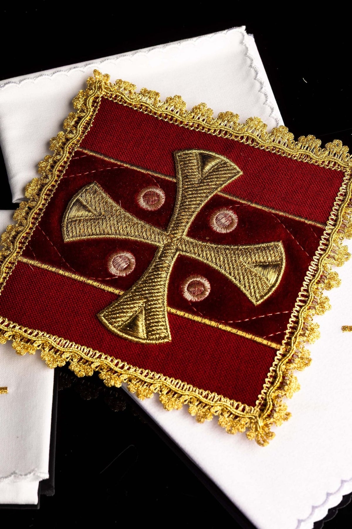 Altar linen set close-up showing red velvet corporal with gold embroidered cross