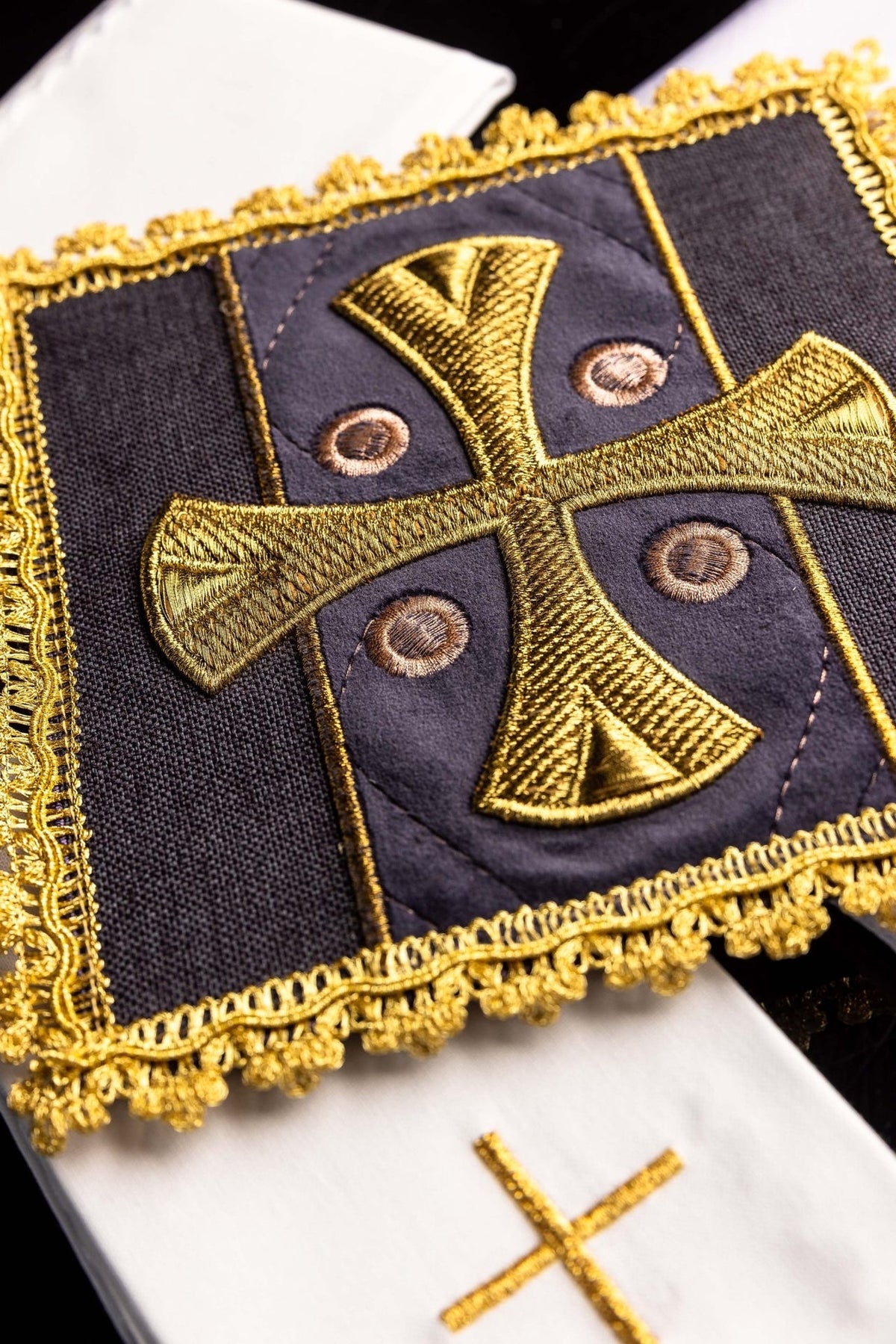 Altar linen set close-up of purple velvet chalice pall with gold cross and decorative trim