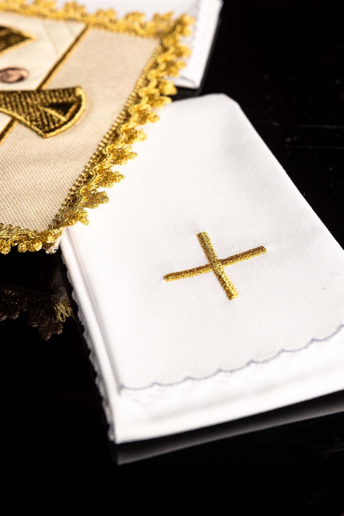 Altar linen set detail showing white linen with gold cross and scalloped edge