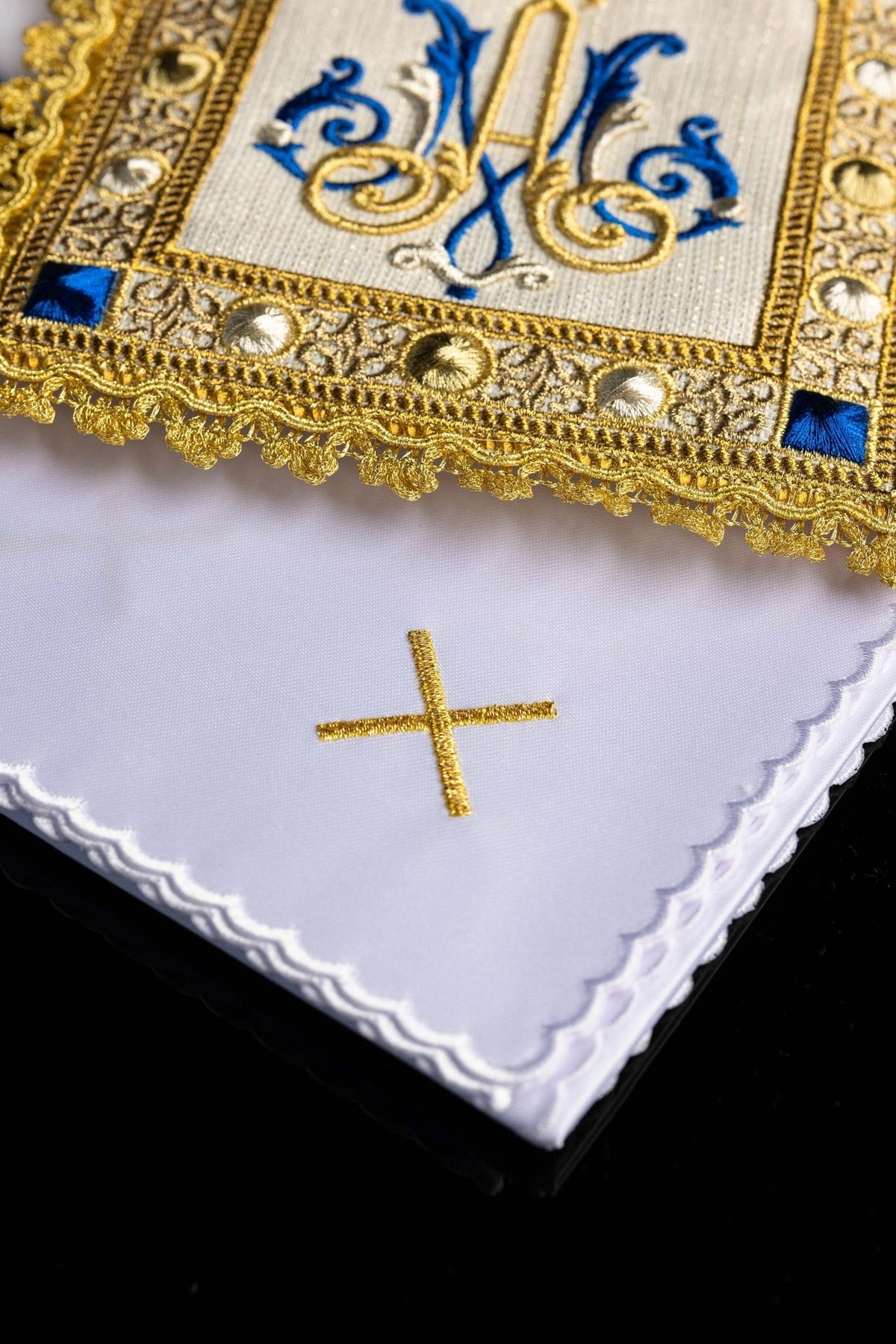 Altar linen set detail showing white fabric, scalloped edge and gold cross embroidery