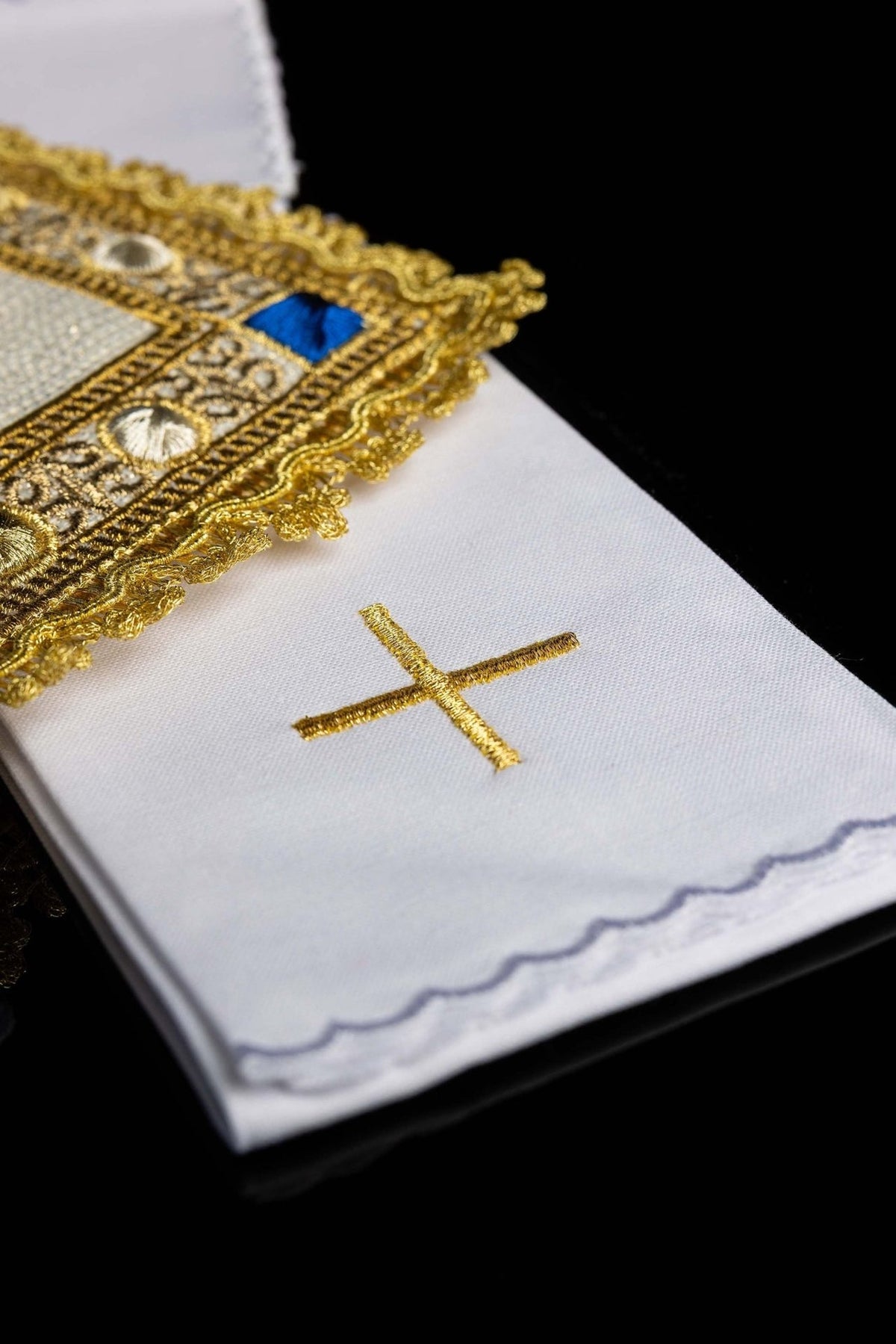 Altar linen set detail showing white linen with gold cross and scalloped edge