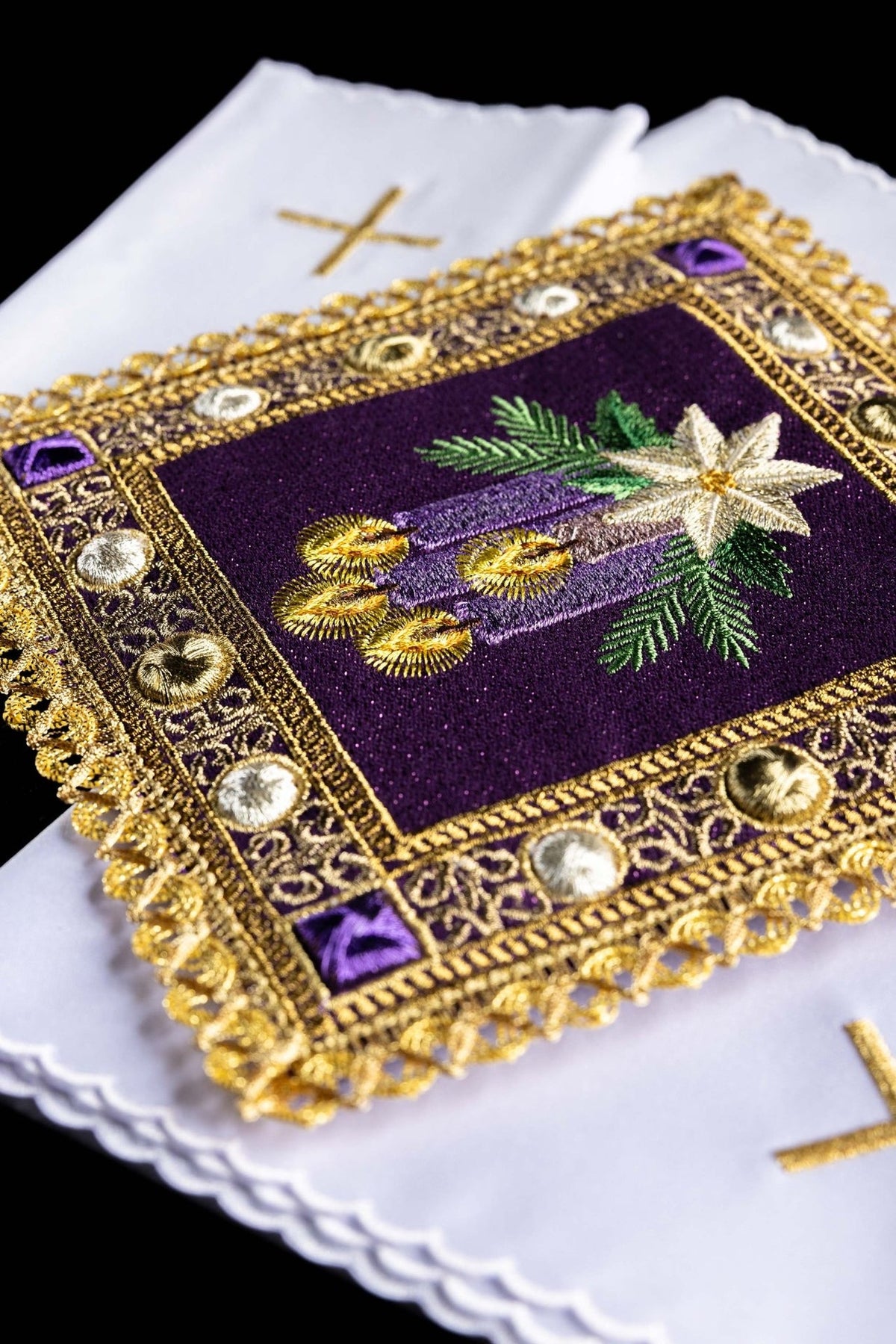 Advent altar linen set detail showing gold cross embroidery on white linen beneath ornate purple trim