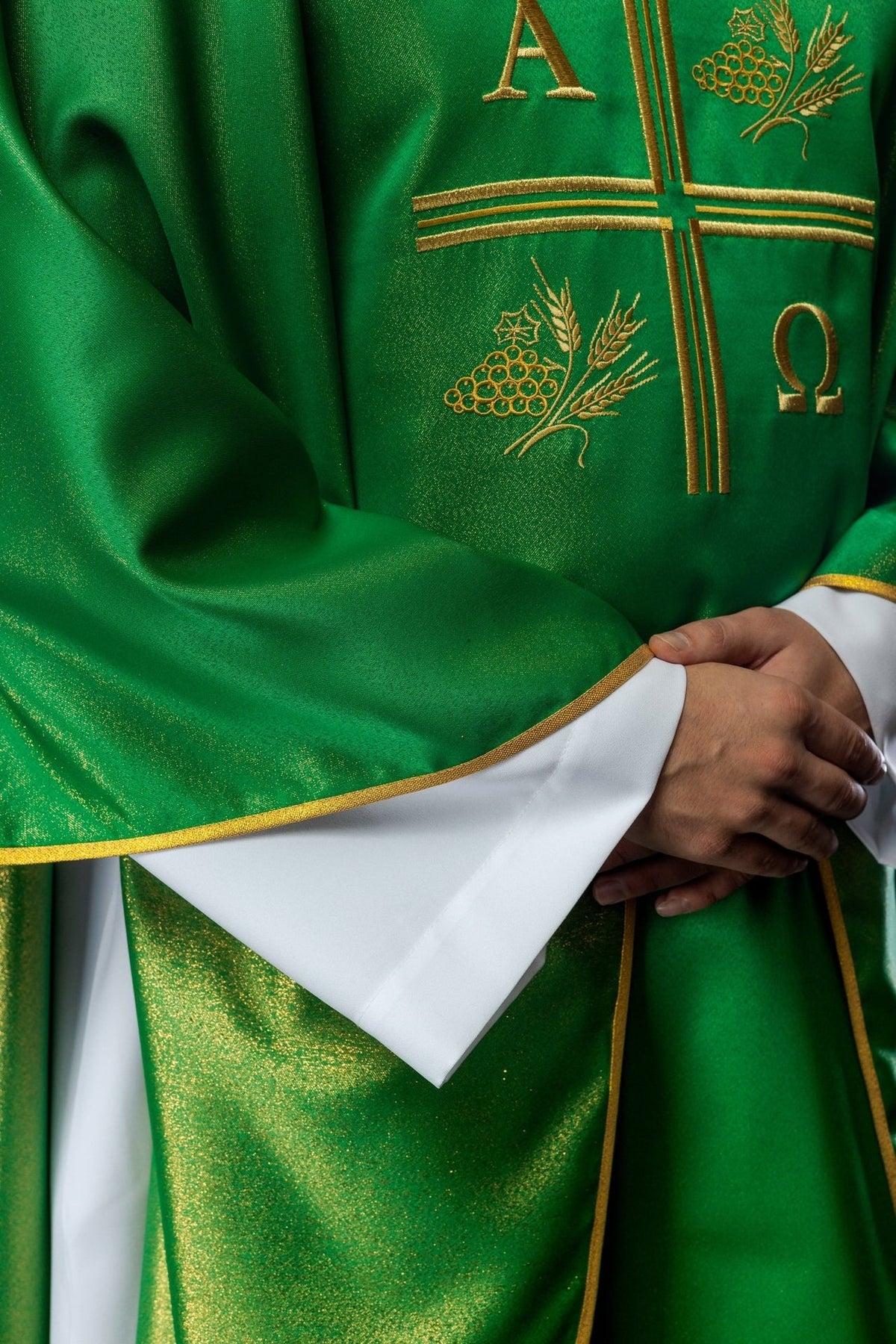 Green chasuble close-up showing gold wheat embroidery and trim