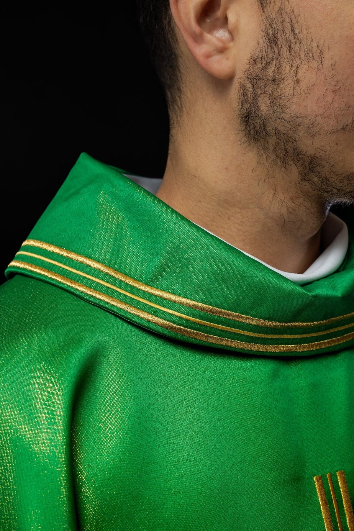 Green chasuble side detail showing gold trim and satin fabric