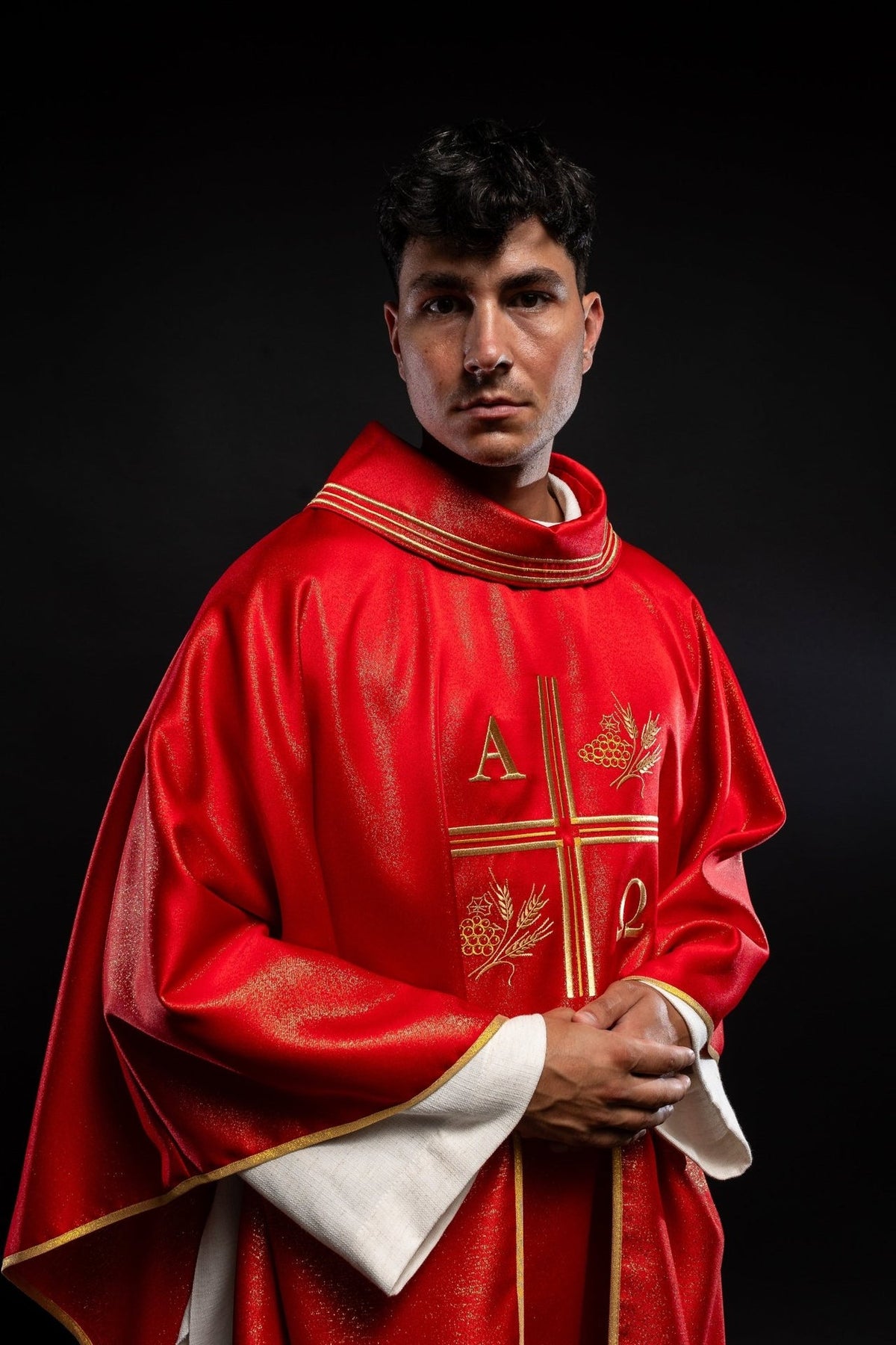 Red chasuble, angled front view with gold trim and embroidered motifs
