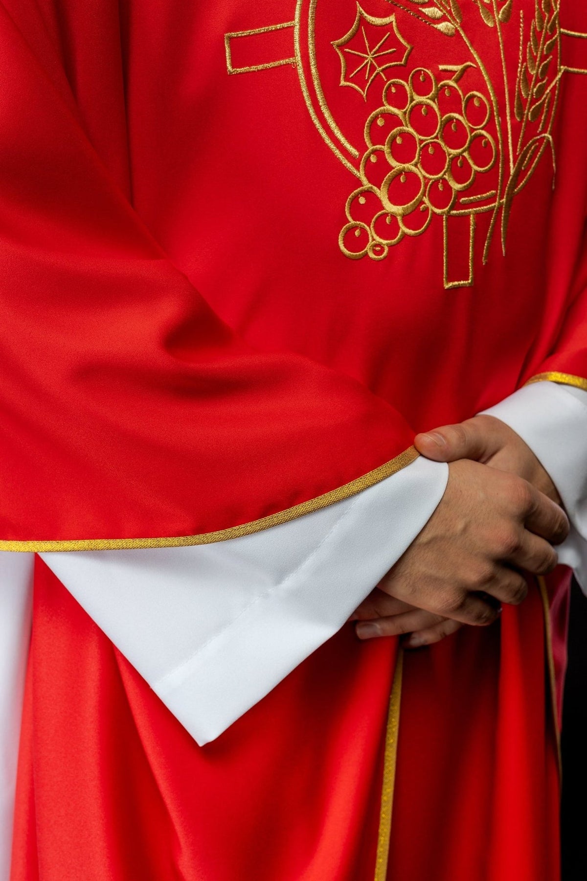 Red chasuble close-up showing gold embroidery and satin trim