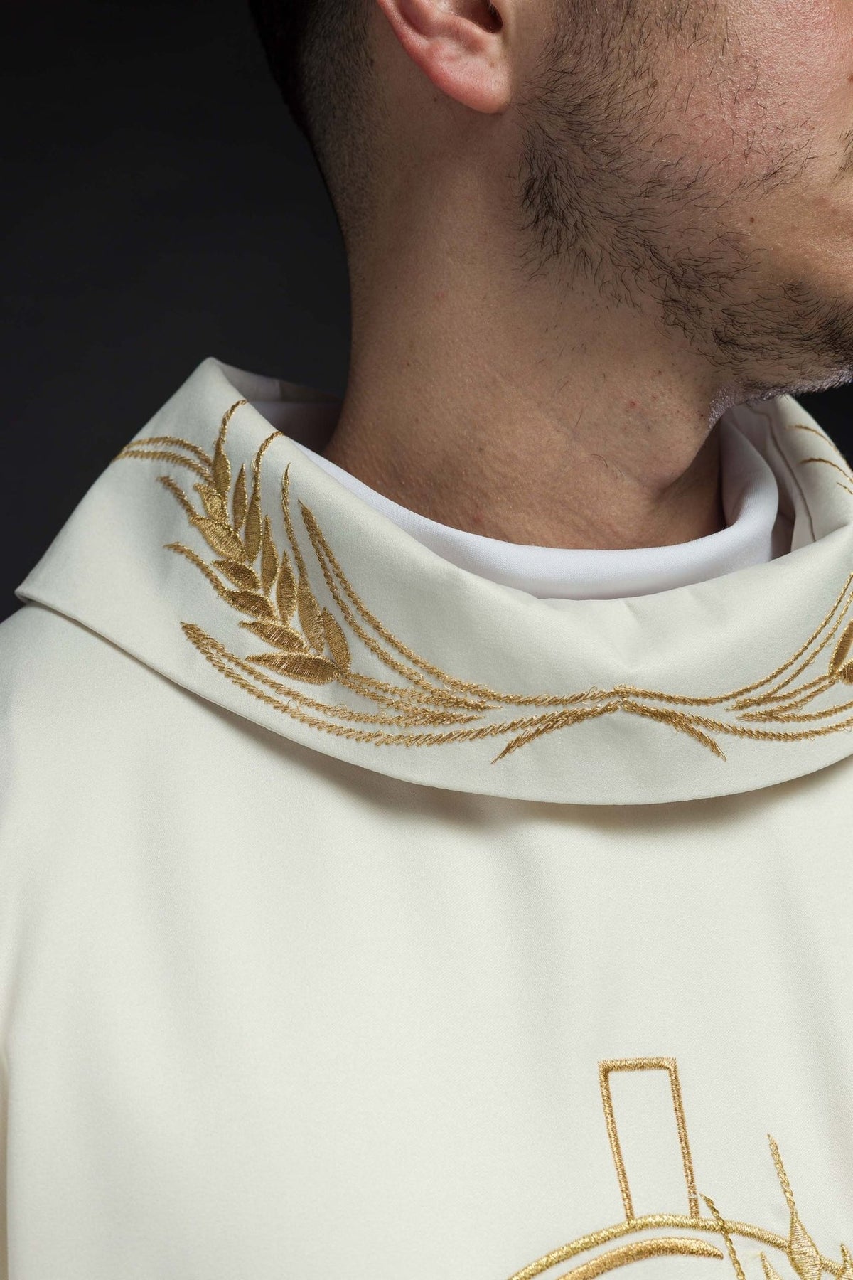 Ecru chasuble close-up showing gold trim and embroidered front motifs