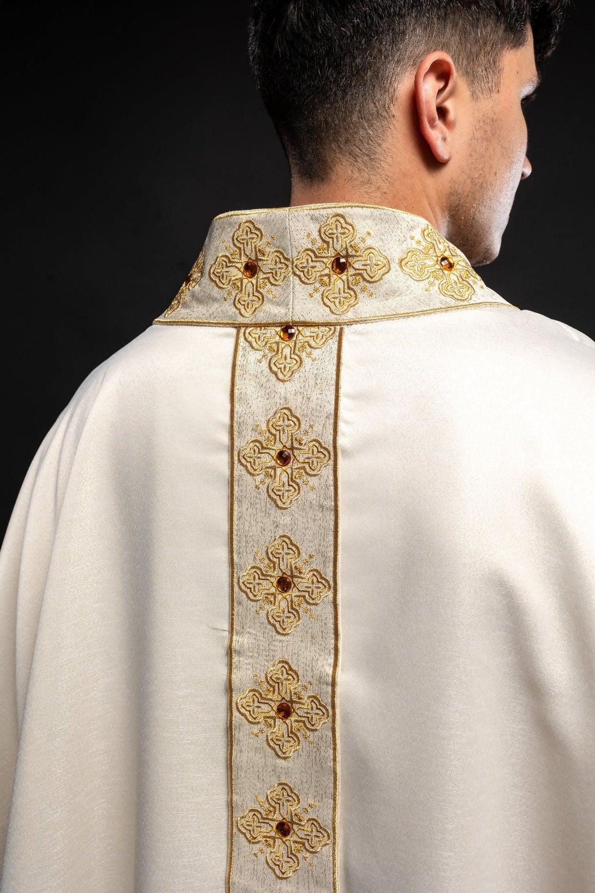 Ecru chasuble back close-up with embroidered orphrey and stone-adorned collar