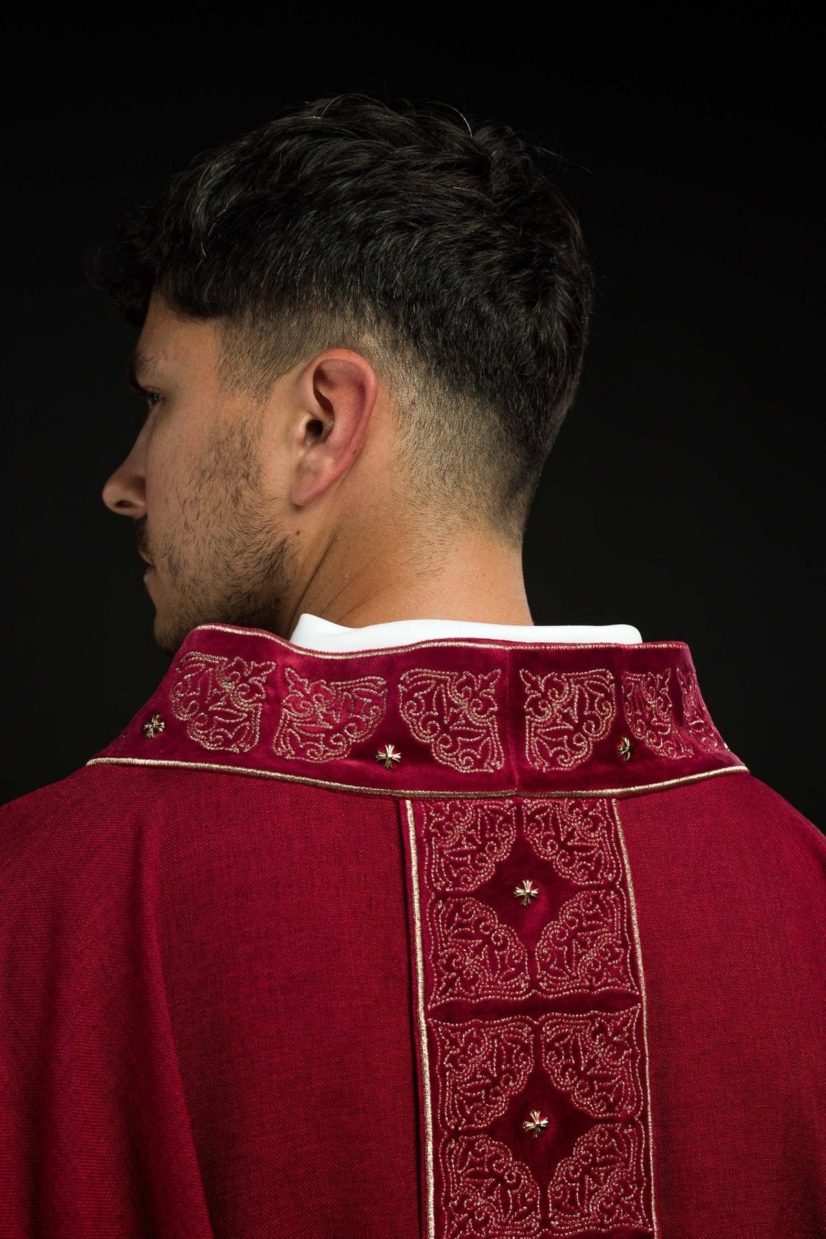 Red chasuble back close-up with gold embroidered collar and orphrey