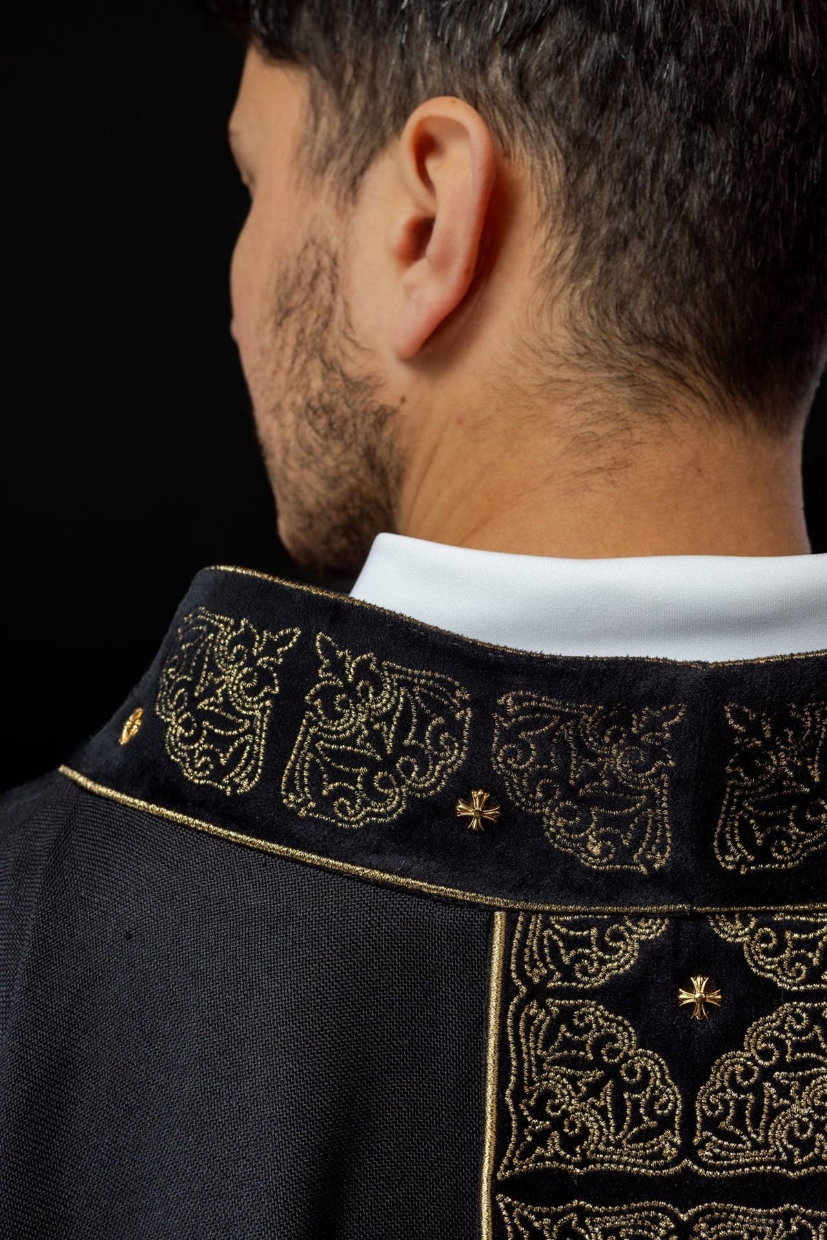 Black chasuble side close-up with gold embroidered collar and orphrey