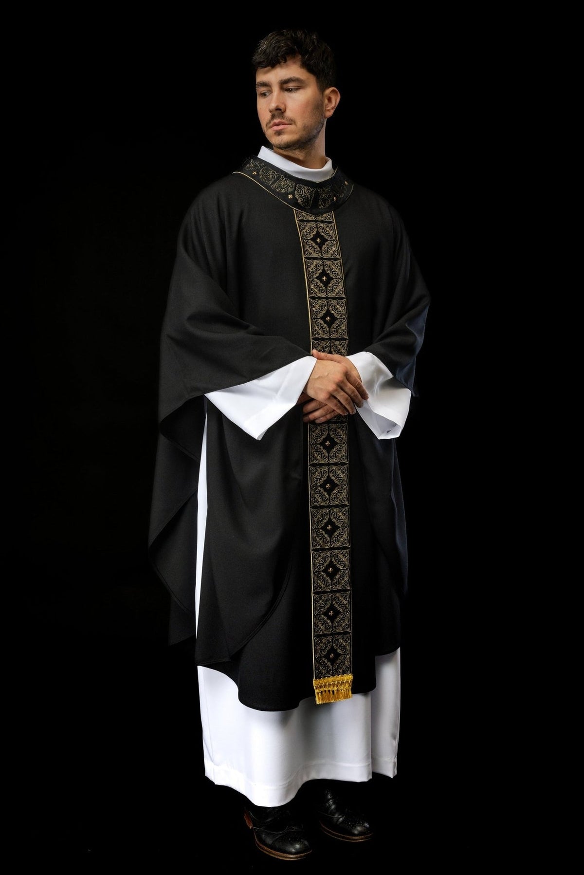 Black chasuble front worn view with gold embroidered orphrey and fringe