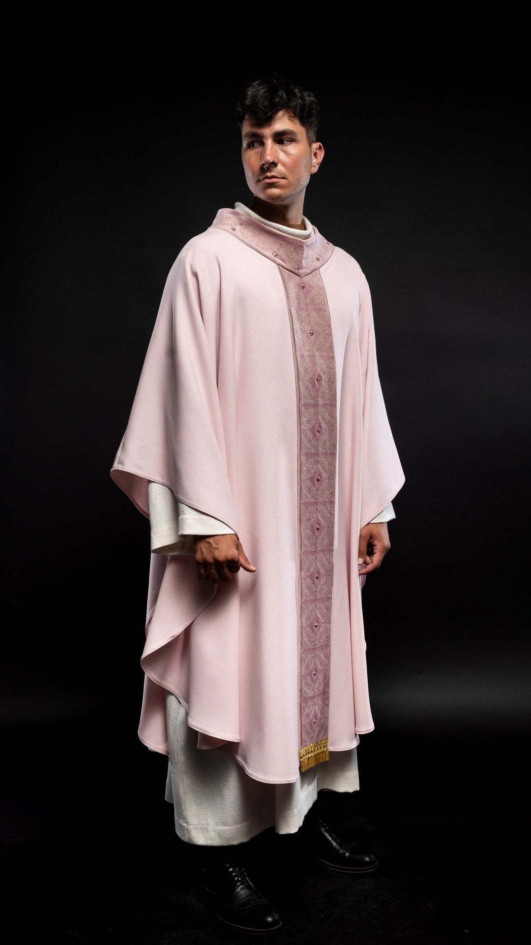 Rose chasuble side view showing flowing rose fabric and embroidered orphrey