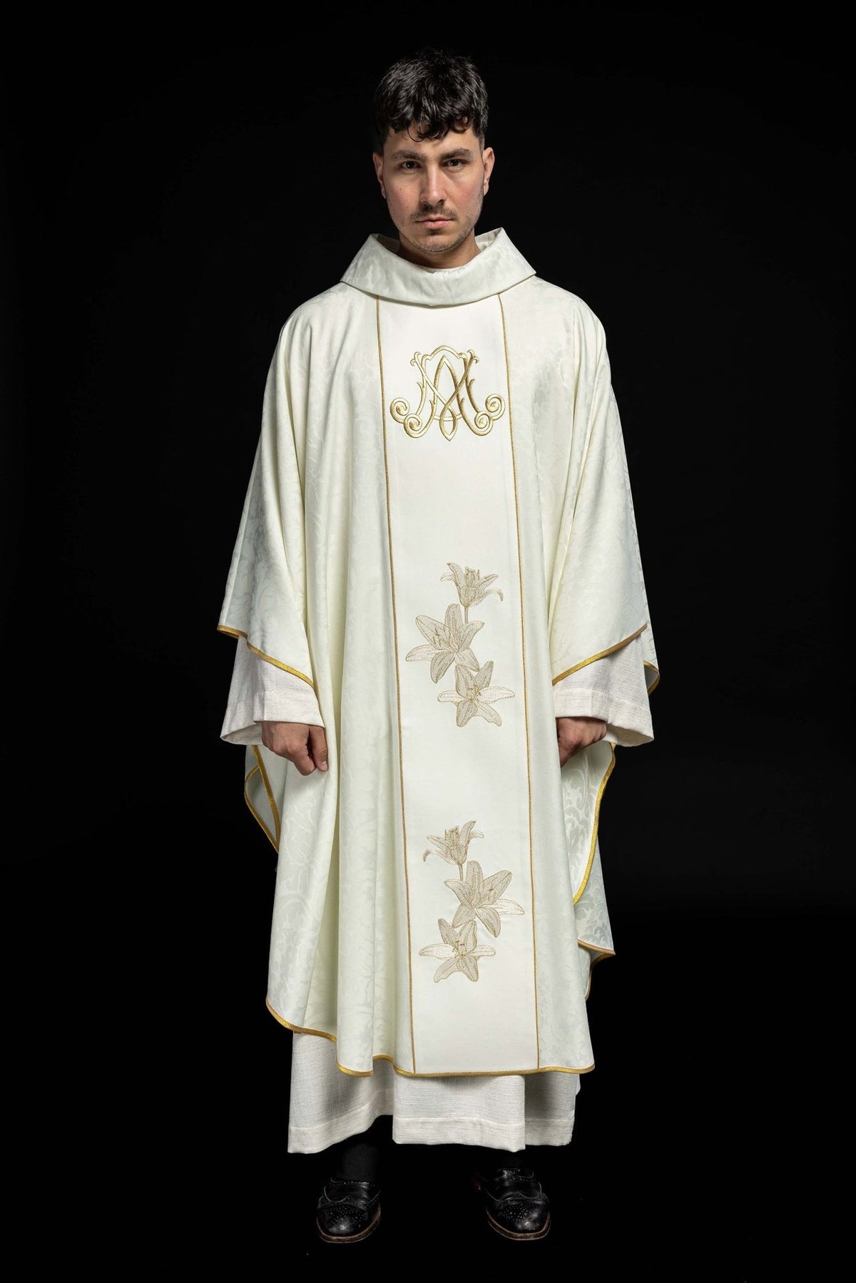Chasuble front view showing ivory fabric, gold edging, Marian monogram and embroidered lilies