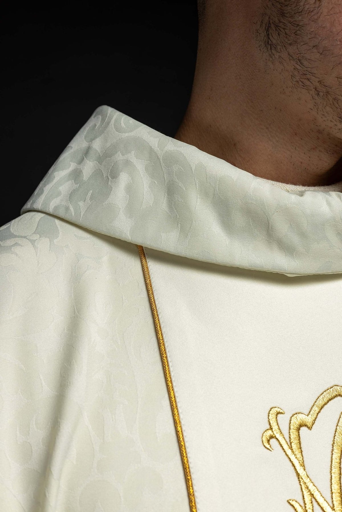 Chasuble close-up showing ivory stand-up collar, brocade pattern and gold trim
