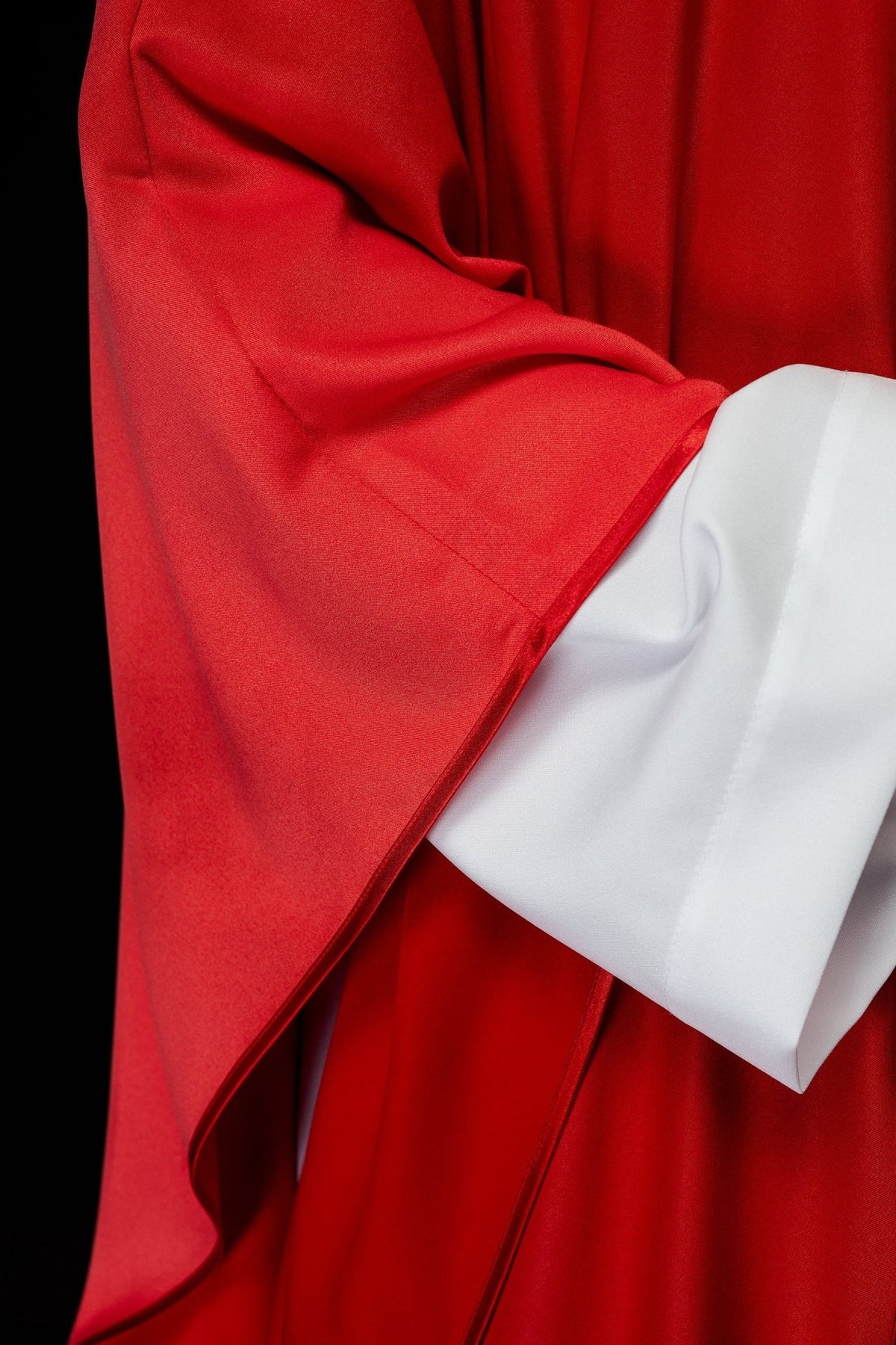 Red chasuble close-up showing the sleeve edge and red trim