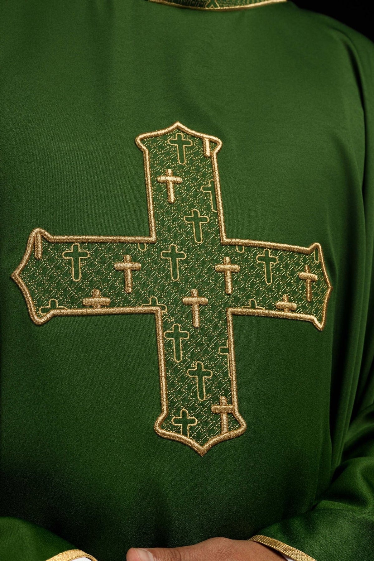 Green chasuble close-up of richly embroidered gold cross