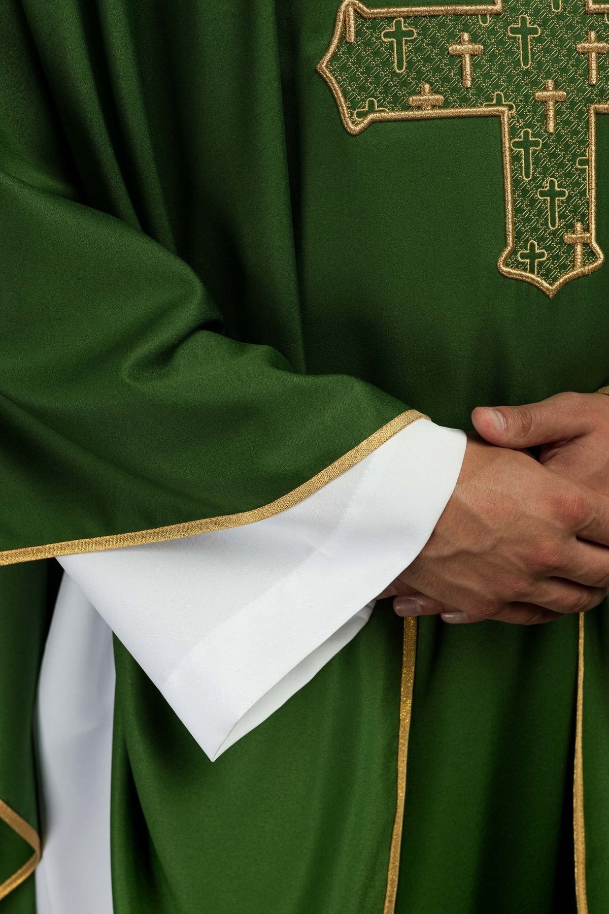 Green chasuble detail showing gold-edged sleeve and white cuff