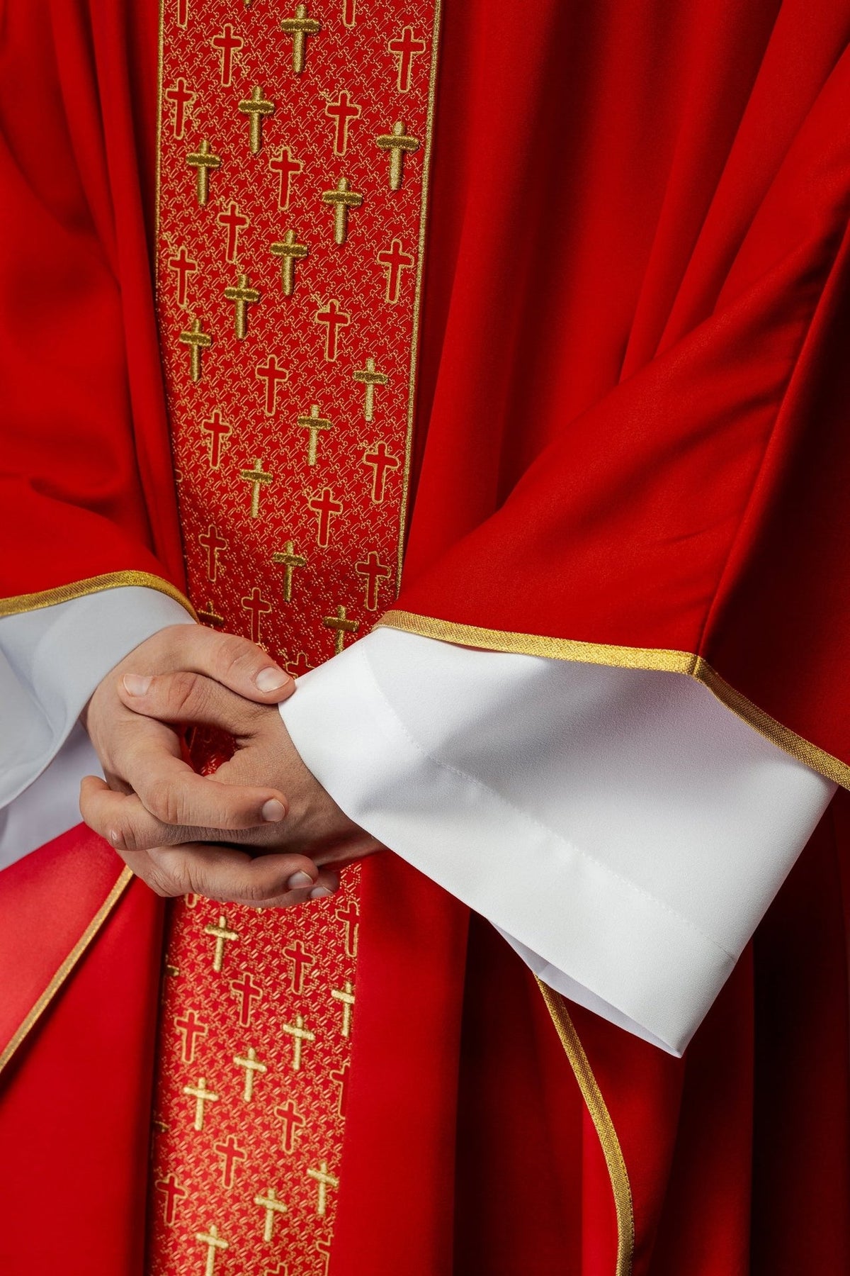Red chasuble detail showing embroidered orphrey, gold edging and sleeve trim