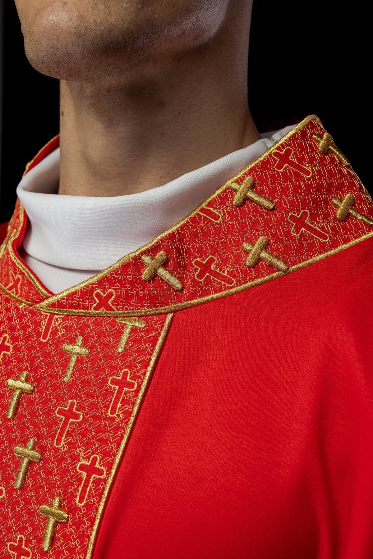 Red chasuble collar close-up with gold cross embroidery
