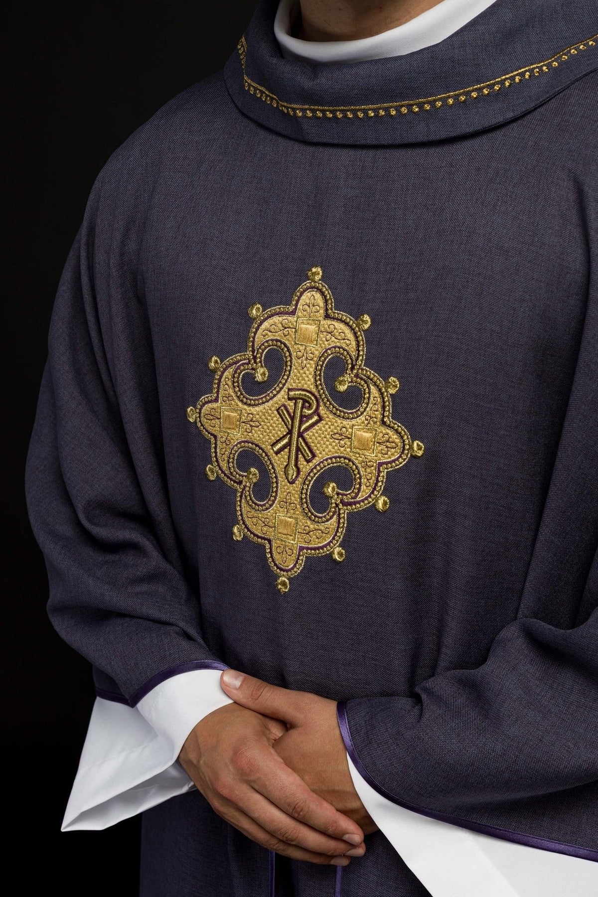 Purple chasuble close-up showing gold embroidered cross