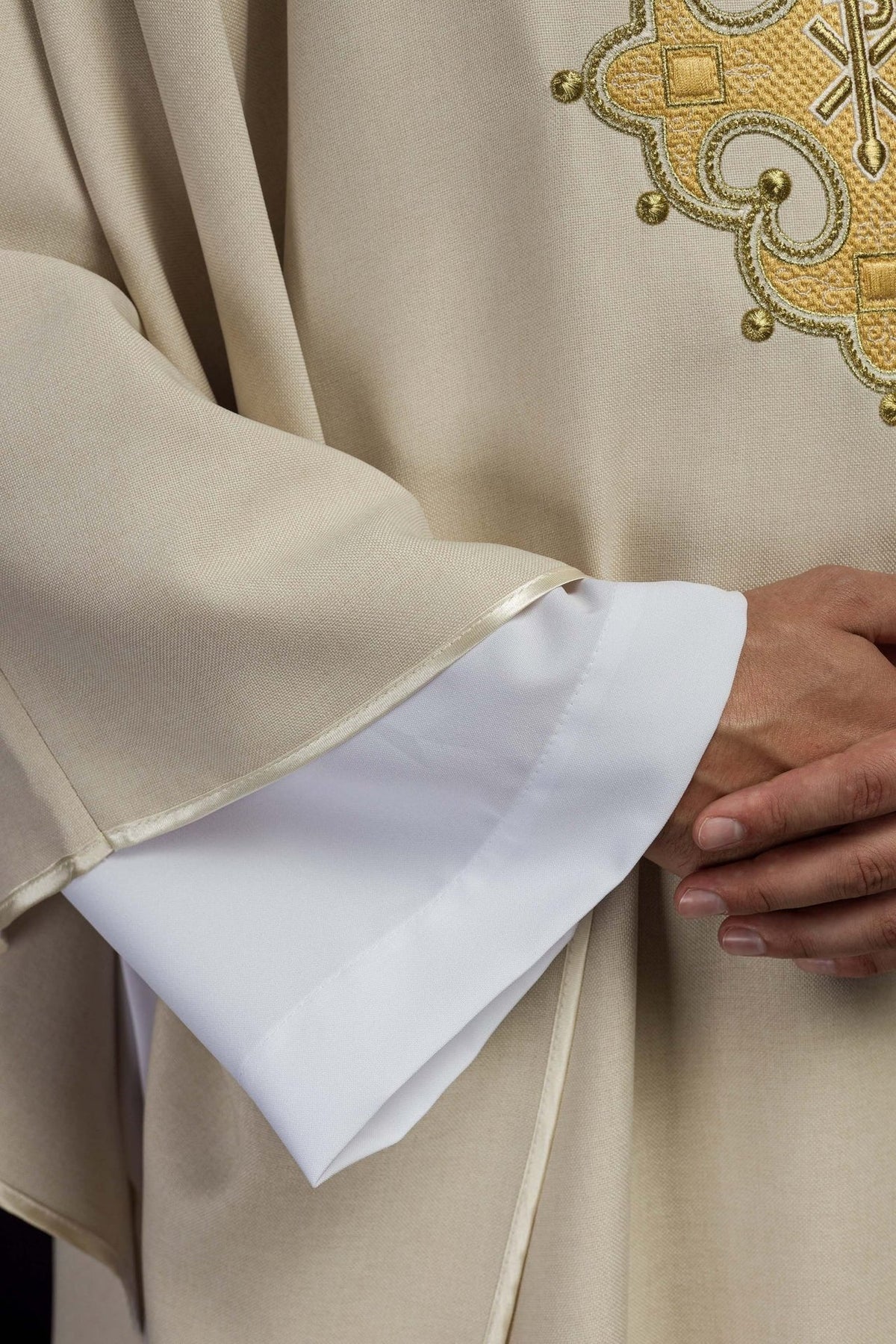 Ecru chasuble close-up showing gold embroidery and sleeve edge