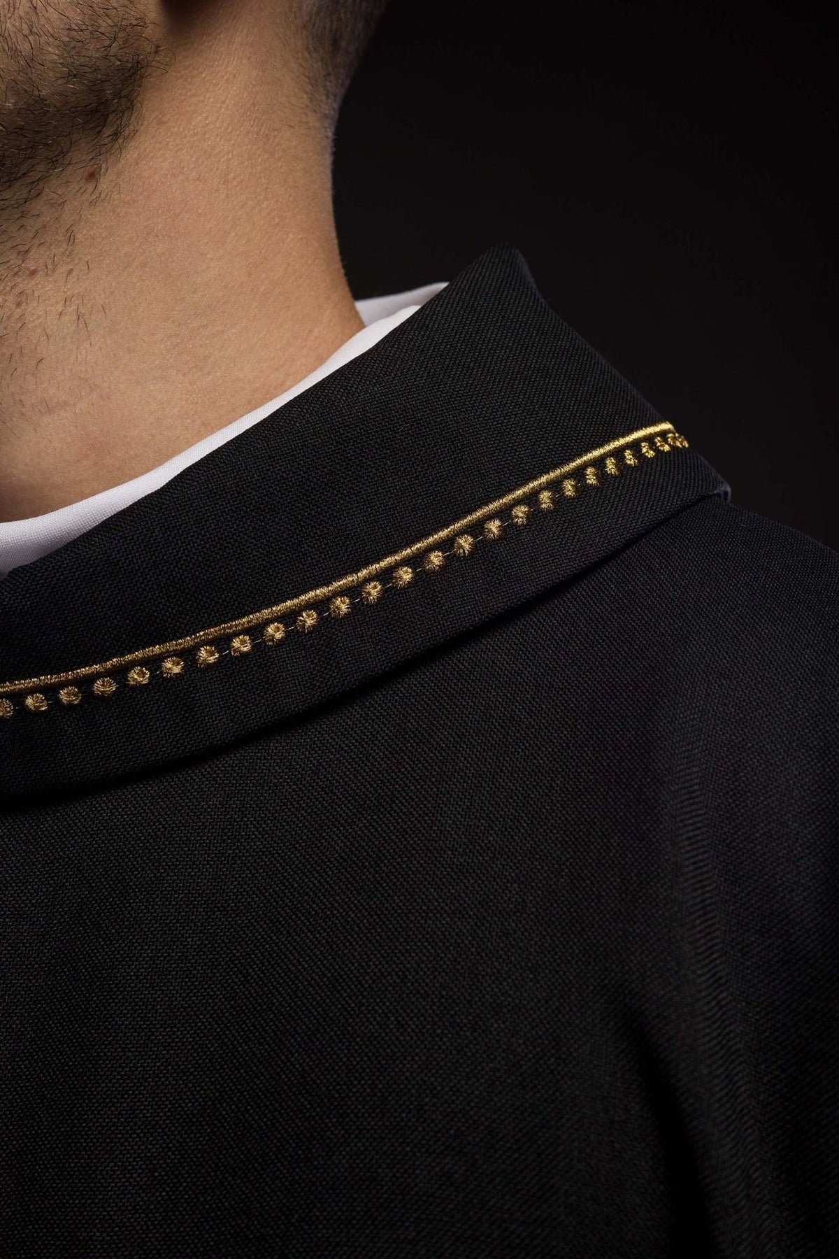 Black chasuble detail showing gold embroidery and black fabric