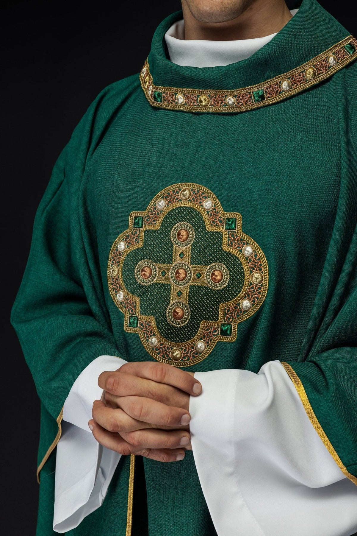 Green chasuble front close-up showing cross embroidery and embroidered trim