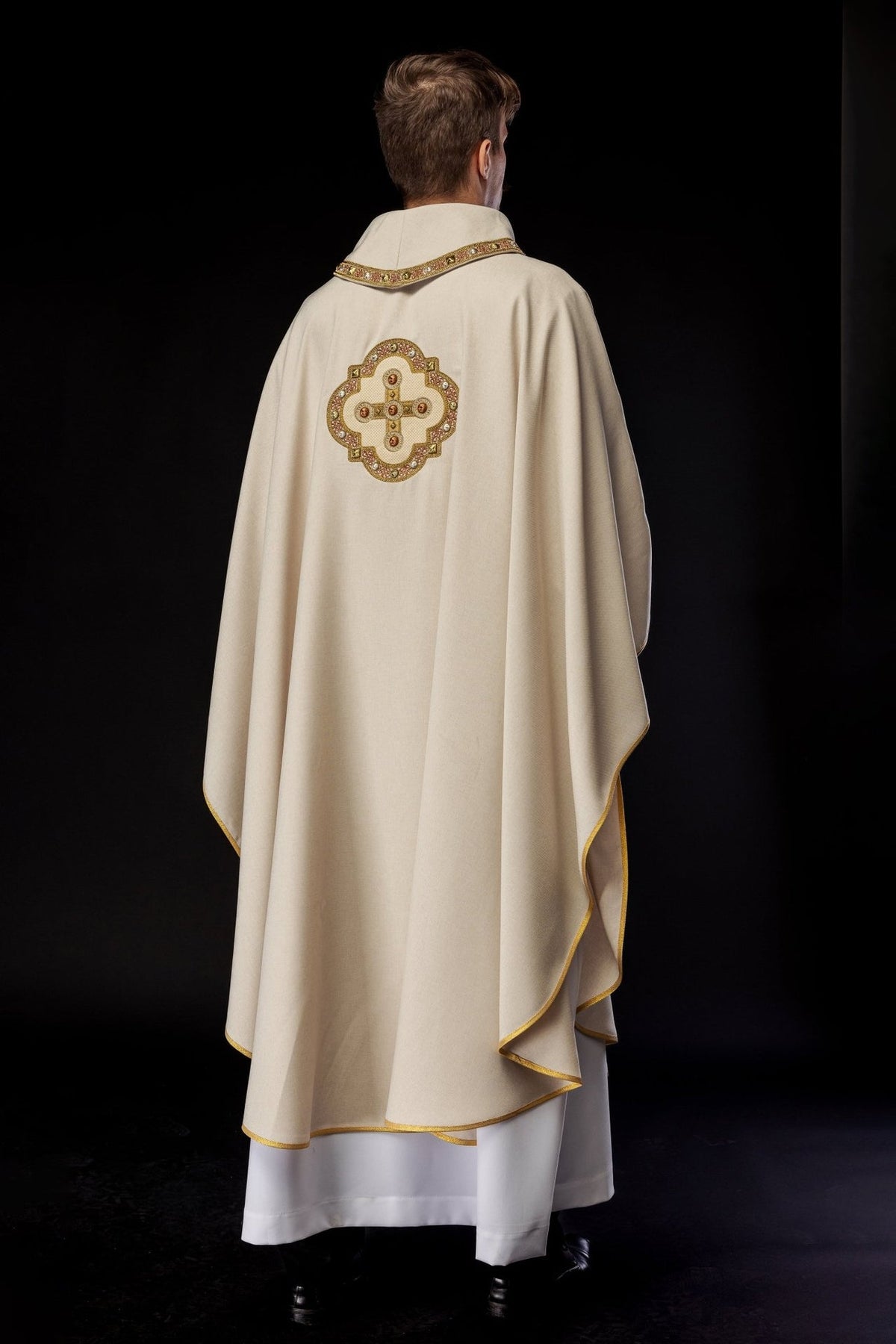 Ecru chasuble, back three-quarter view with gold trim and cross embroidery