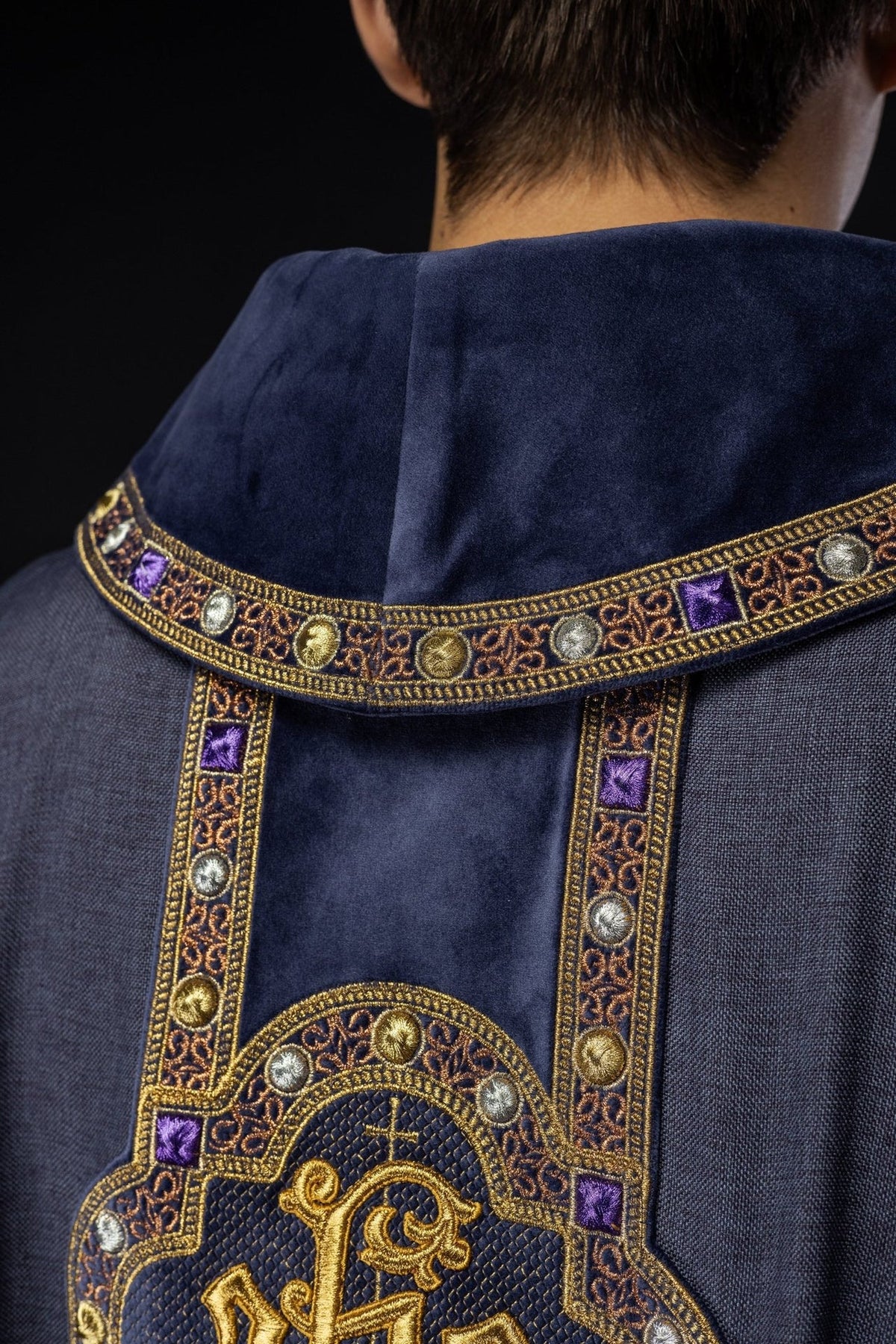Purple chasuble back close-up showing embroidered trim and orphrey