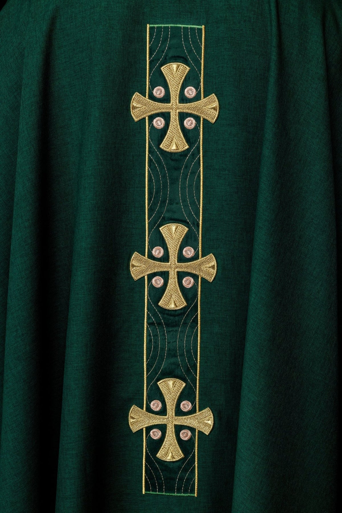 Chasuble close-up showing gold cross embroidery on the green front panel