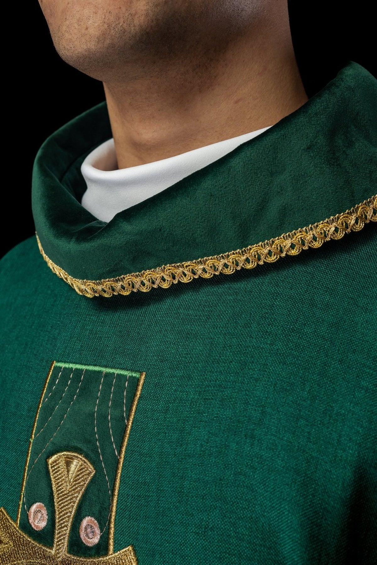 Chasuble close-up showing gold trim on the green collar and cross embroidery