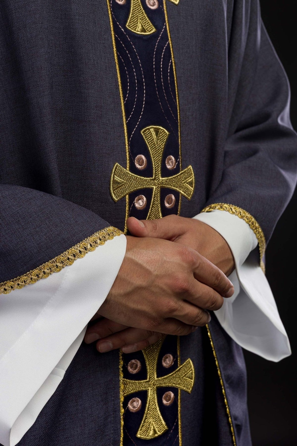 Purple chasuble detail showing gold cross embroidery and sleeve trim