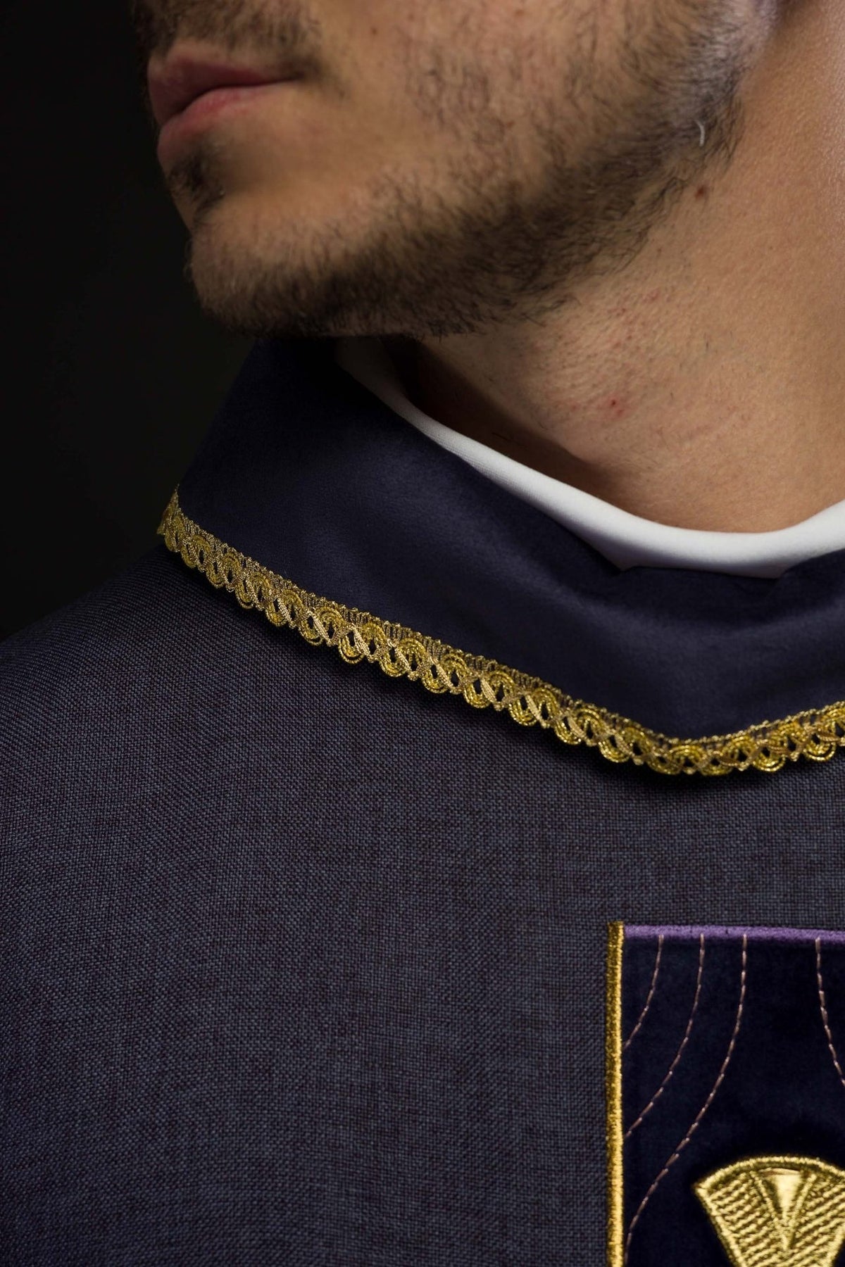 Purple chasuble close-up of embroidered gold cross and collar trim