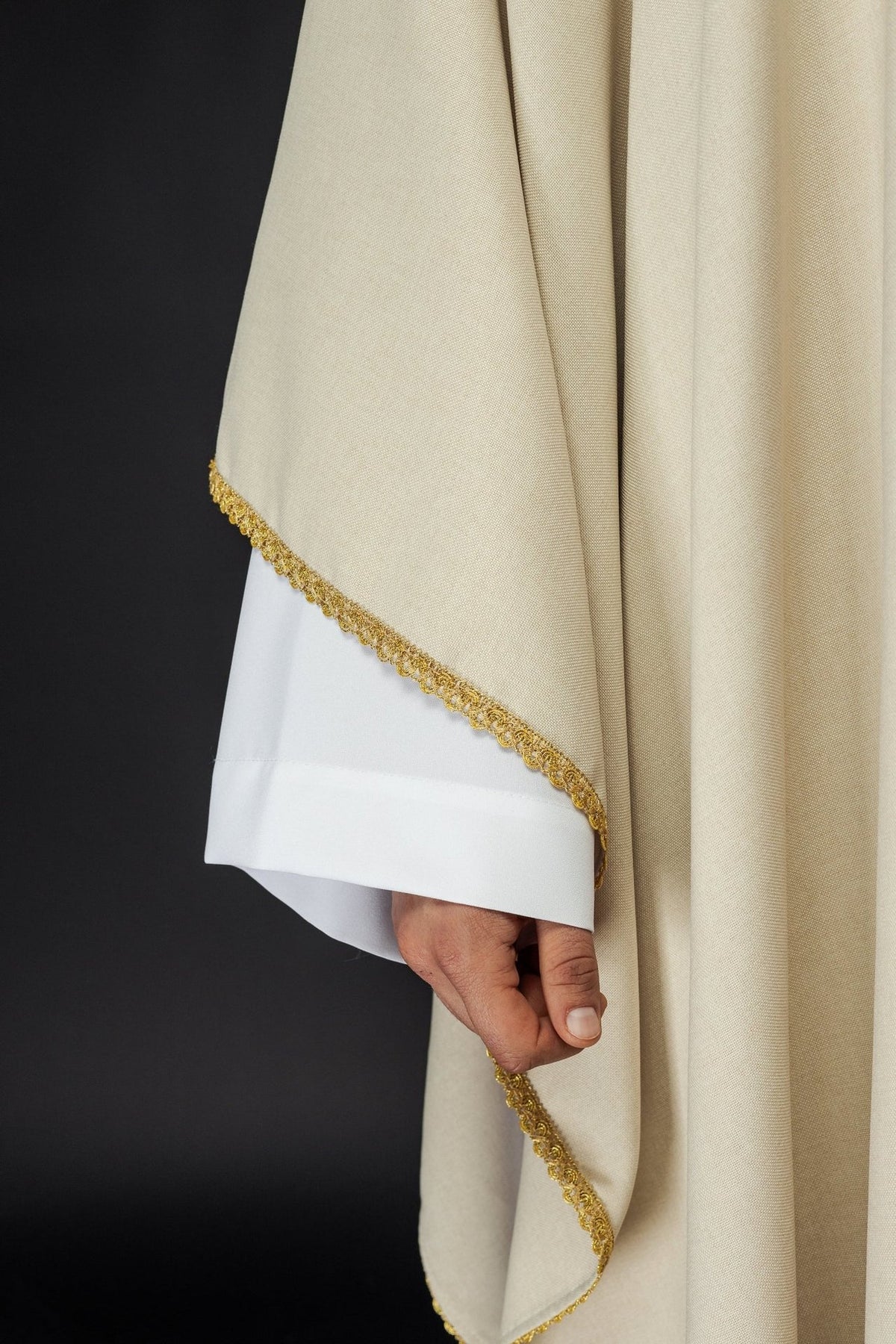 Ecru chasuble side detail with gold trim on the sleeve edge