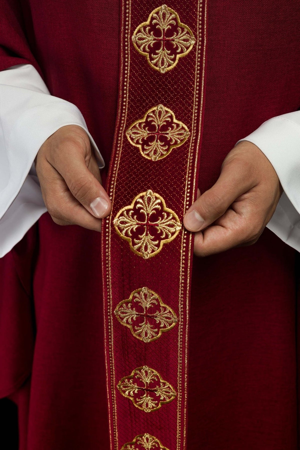 Red chasuble orphrey close-up with repeated gold embroidery