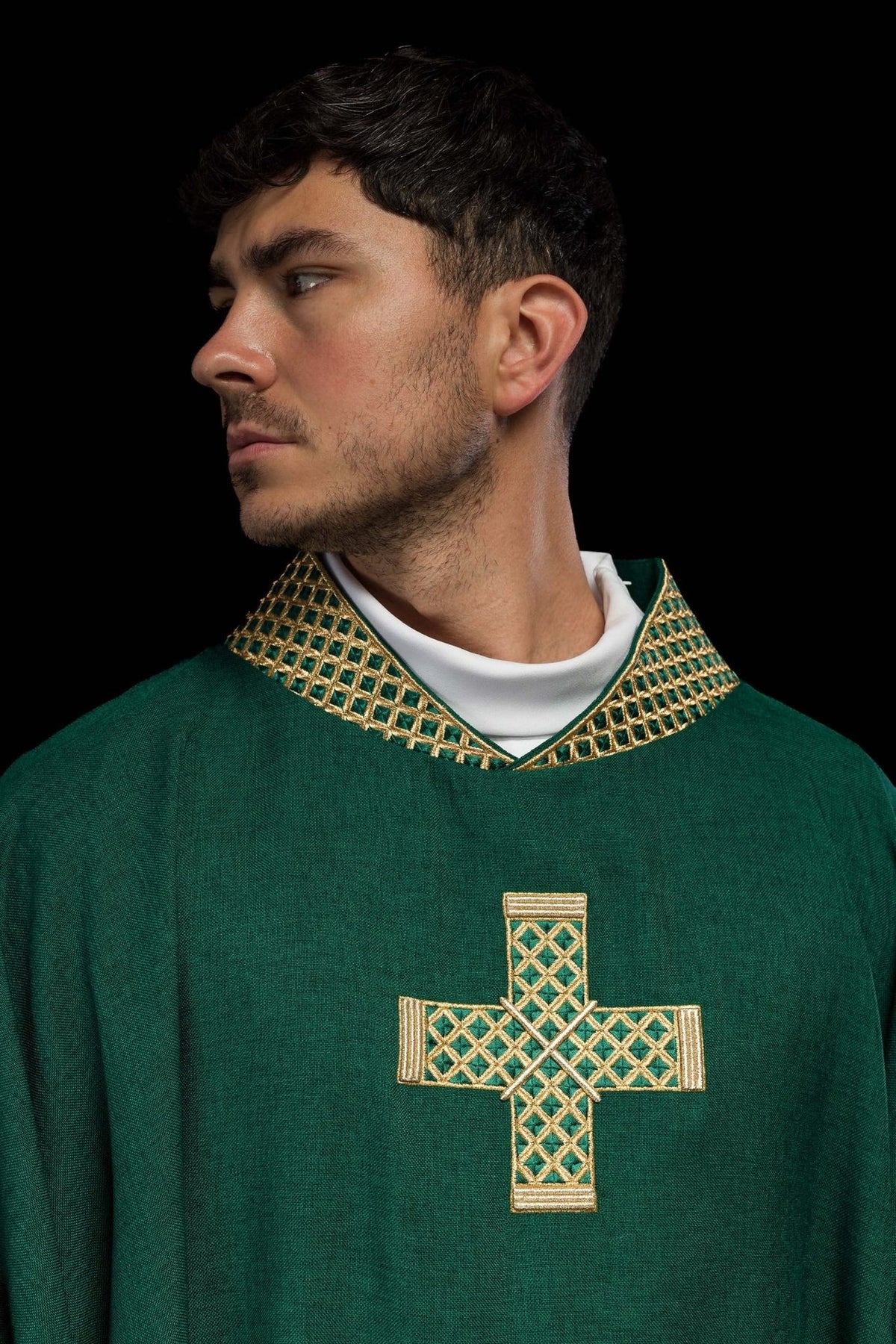Green chasuble close-up showing gold embroidered cross and collar
