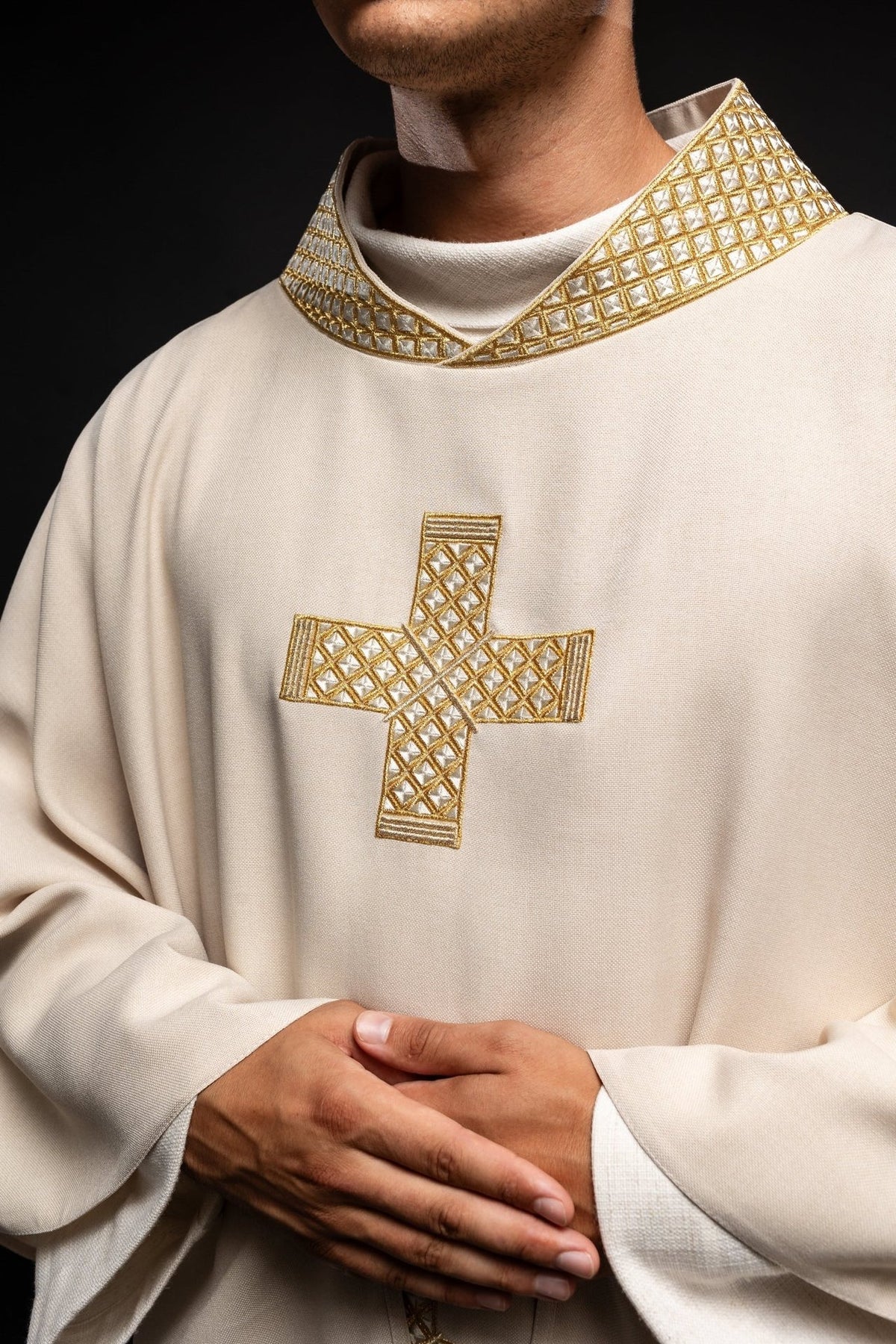 Ecru chasuble close-up with gold embroidered cross and collar