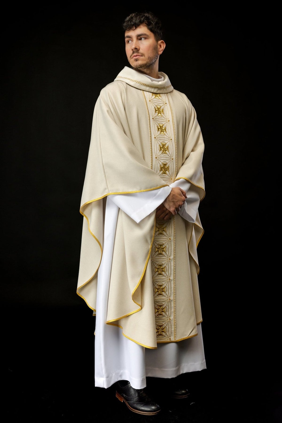 Ecru chasuble worn in a front three-quarter view with gold embroidered cross orphrey