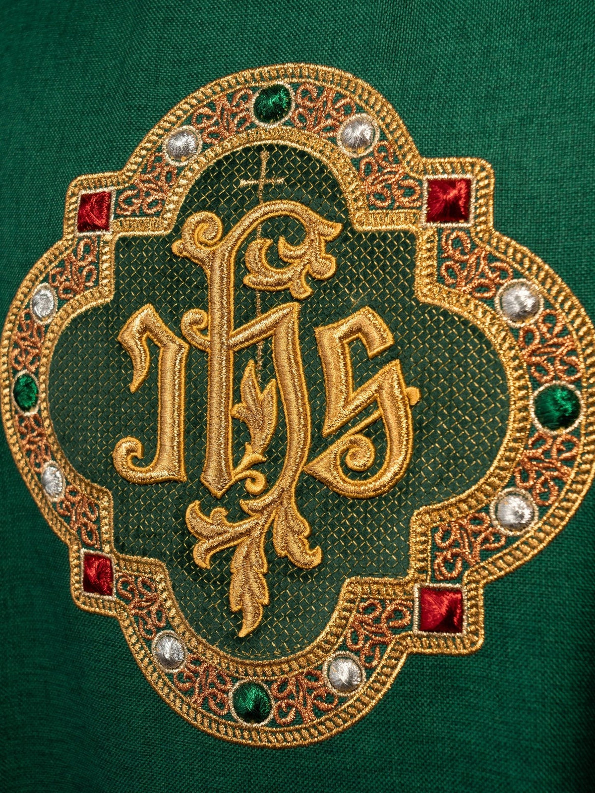 Green chasuble IHS embroidery close-up with gold, red, green and silver details